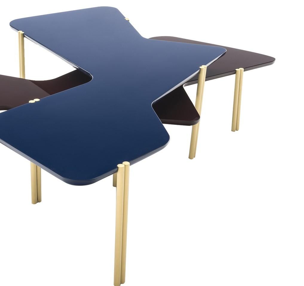 Inspired by the organic forms of Hans Arp's abstract compositions, these tables are defined by wavy lines that evoke the shapes of plants and other natural motifs. The tops are made of wood with a lacquered finish (one black and one cobalt) and each