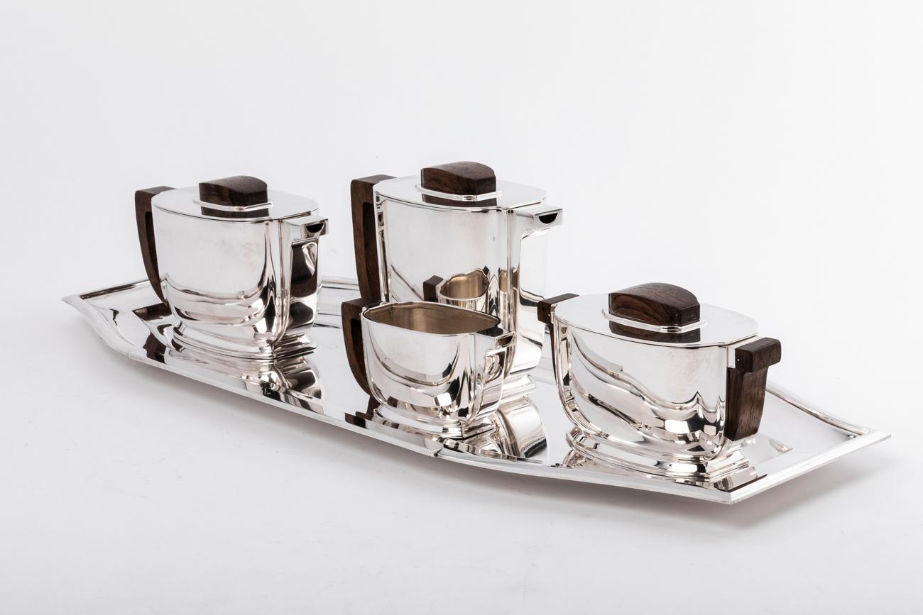 Jean Tetard / Christofle 5 pièces tea / coffee set and silver tray Art Deco

This service consists of a teapot, a coffee maker, a milk jug and a covered sugar bowl; It is oblong in shape, the grips and handles are in rosewood. It rests on a silver