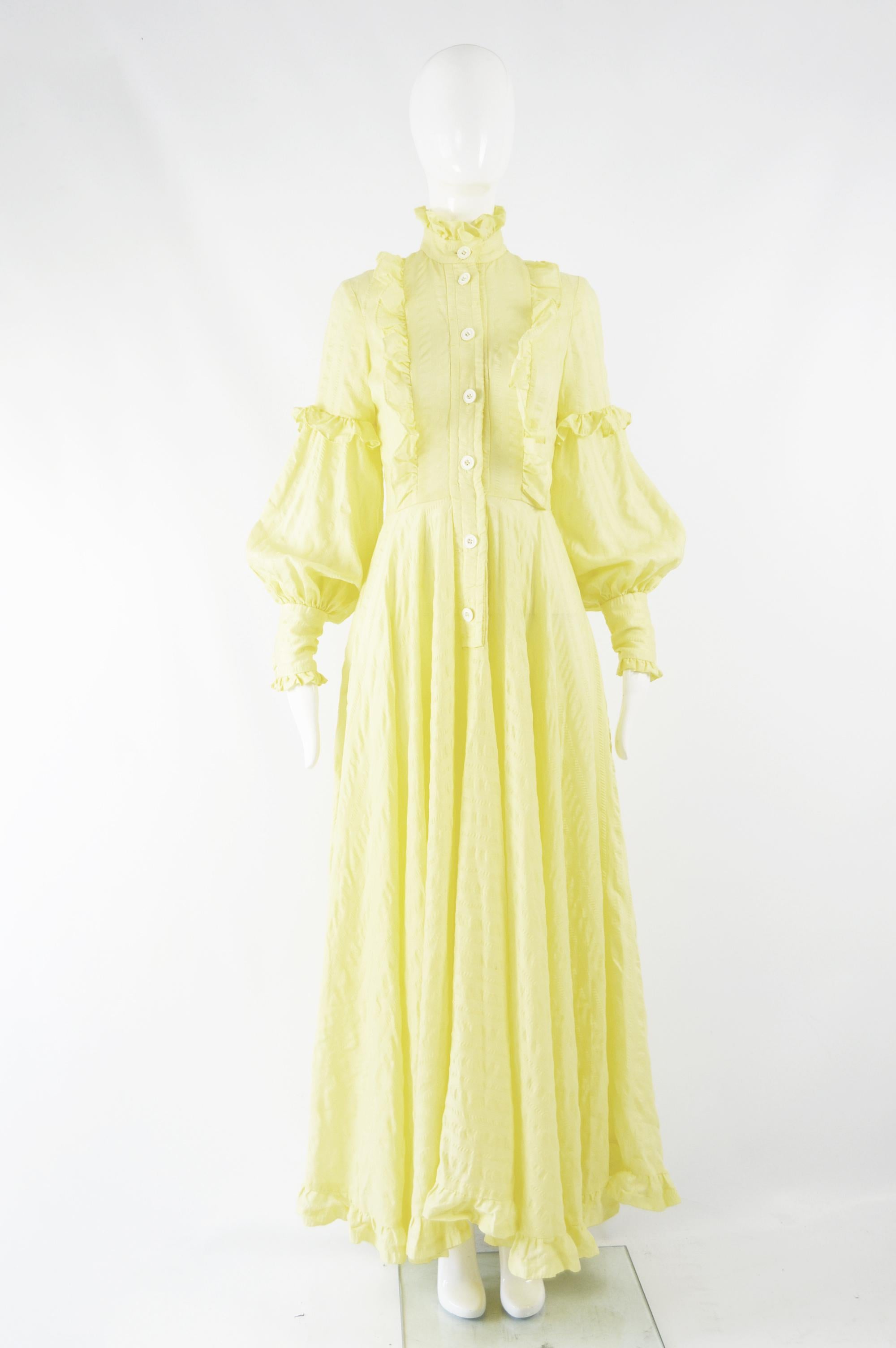 A breathtaking vintage women's boho/ prairie style full length maxi dress from the 70s by iconic British fashion designer Jean Varon. In a pastel yellow cotton seersucker voile with huge balloon sleeves, frilly high neck and huge, full skirt.