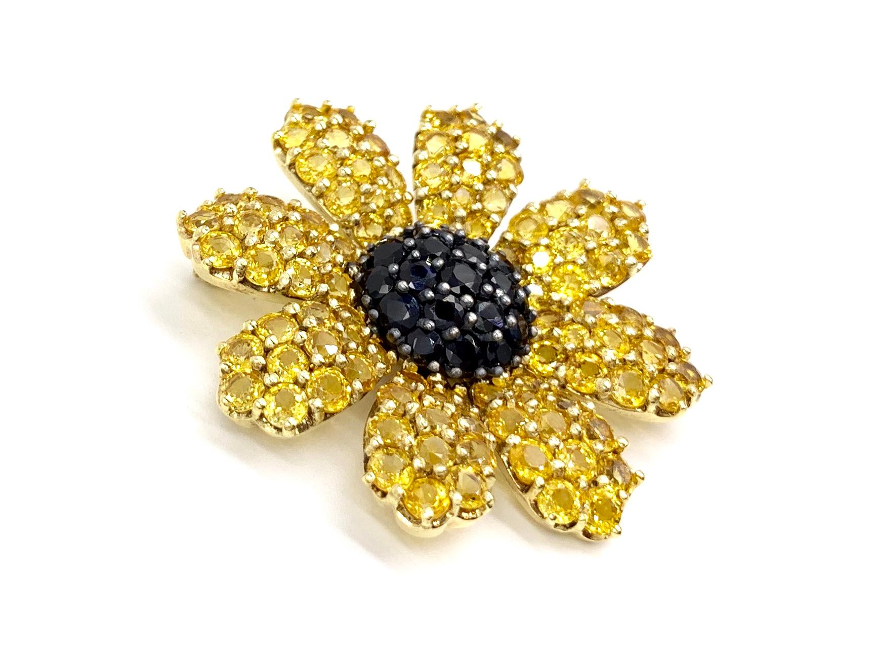 A stunning flower brooch expertly crafted by Jean Vitau. This 18 karat yellow gold Black-Eyed Susan flower brooch features 13.38 carats of striking yellow sapphires on the petals and 4 carats of rich ebony sapphires in the center. Stones are