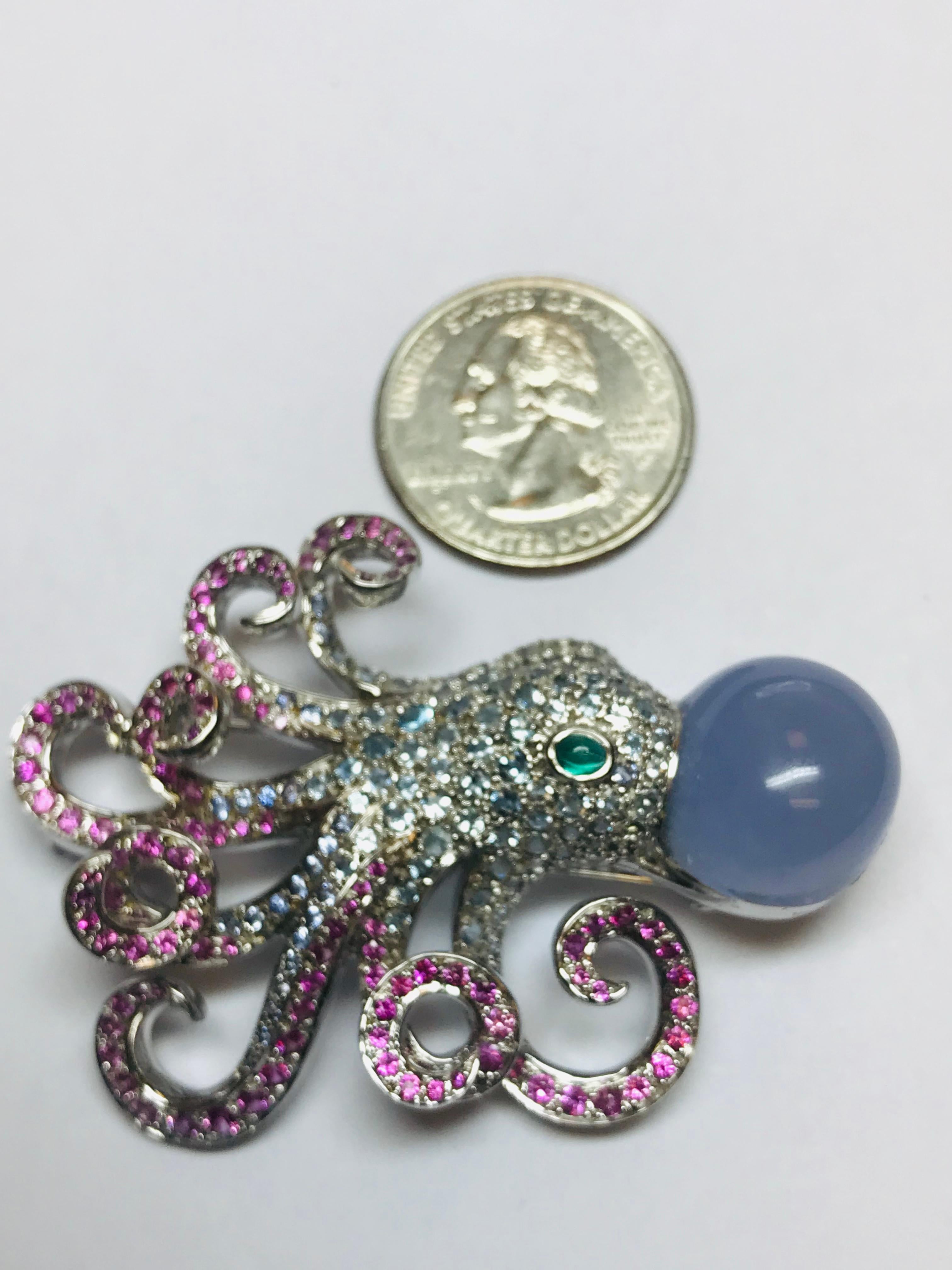 This whimsical 18k white gold Jean Vitau Octopus brooch combines 4.00 carats of light blue Aquamarines in the body with 2.75 carats of Pink Sapphire and a beautiful cabochon Chalcedony, finished off with an emerald eye. So incredibly manufactured