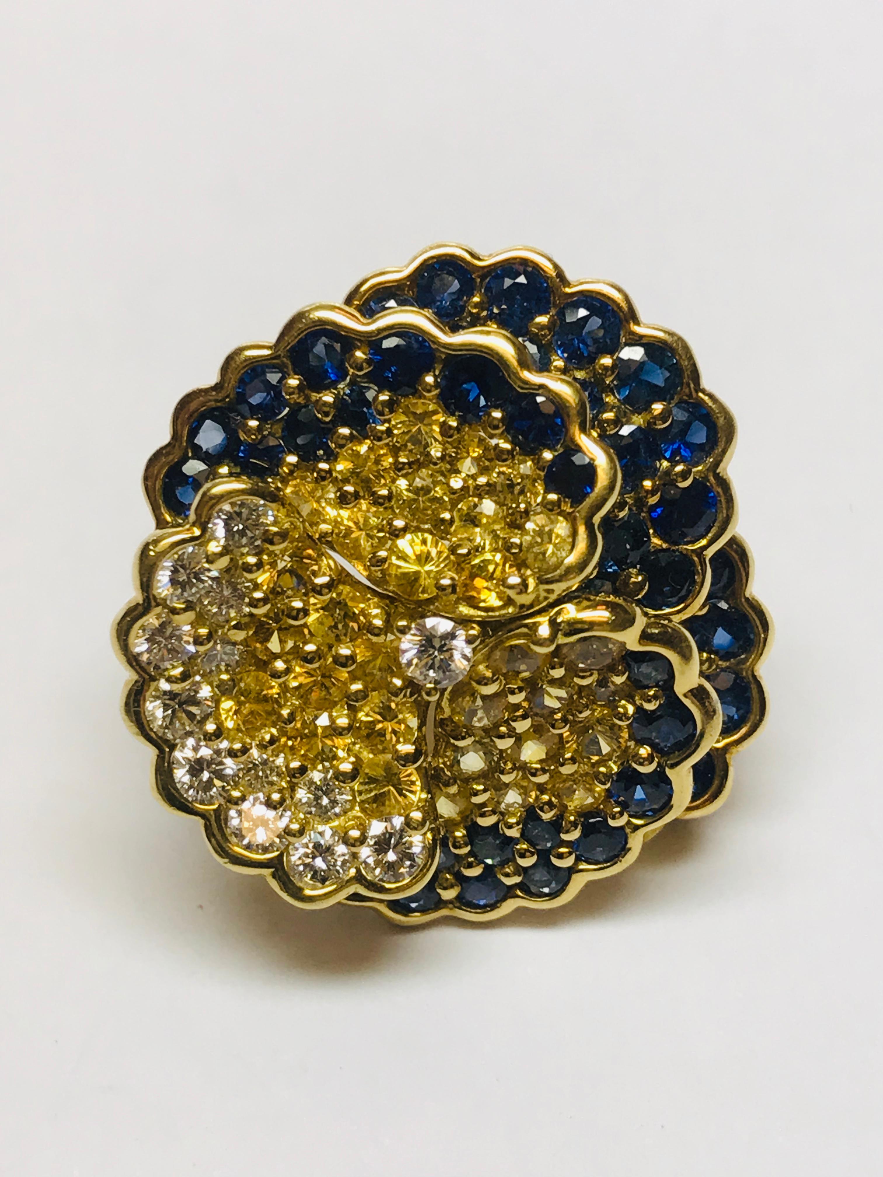 This brooch/ pendant designed and manufactured by Gemlok, combines a total of 6.61 carats of yellow and blue gem quality sapphires with .75 carats of white diamond. 