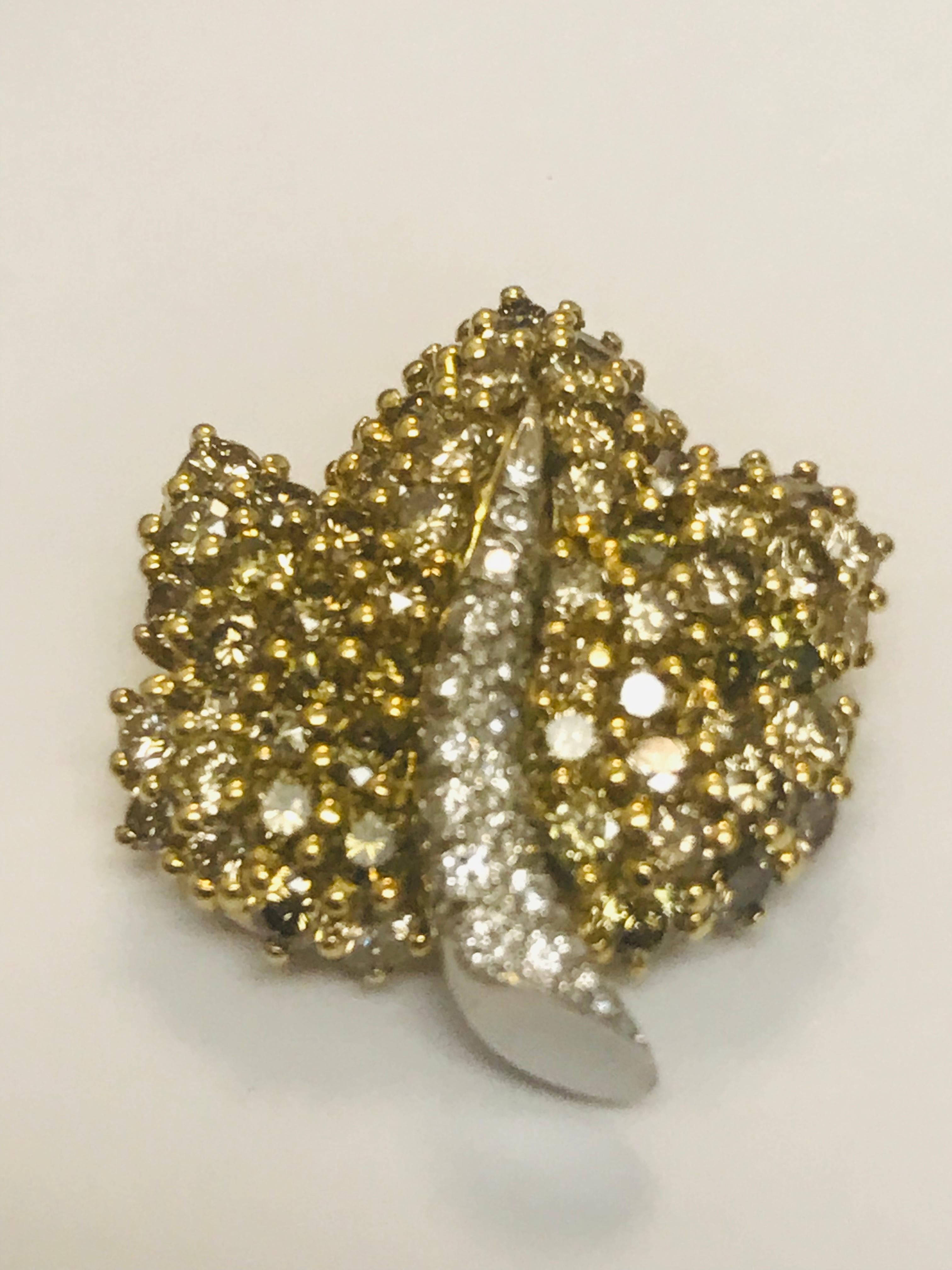 This extremely unique combination of 3.69 carats of Olive colored diamonds and .24 carats of white diamonds really  is a stunner. Designed and created by Jean Vitau, the subtle colors make this pin very wearable with anything. This piece can be