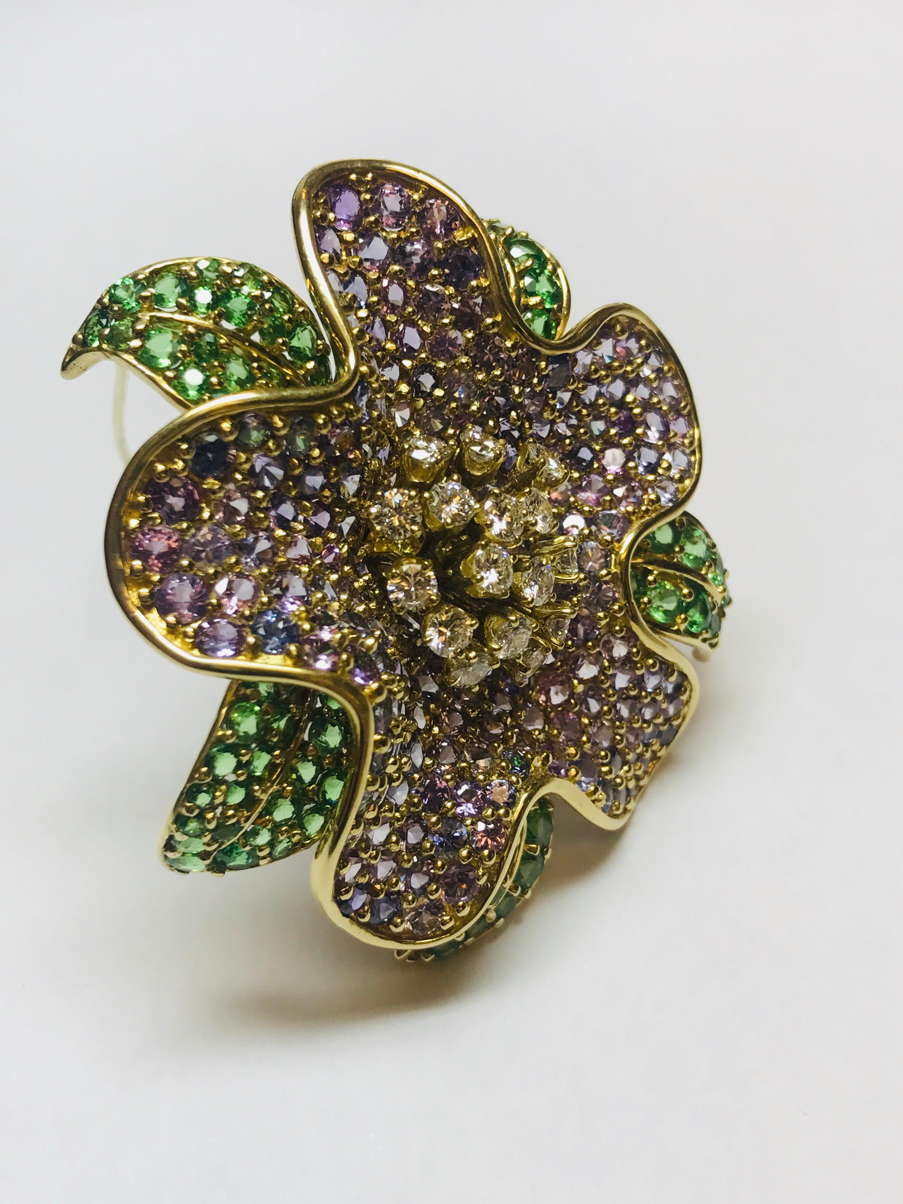 This color combination and craftsmanship of this Rhododendron flower brooch is so incredible. The 20.85 carats of incredible Purple Sapphires with 6.36 carats of richly Green Tsavorite garnets and 1.85 carats of  G+ color VVS clarity diamonds works