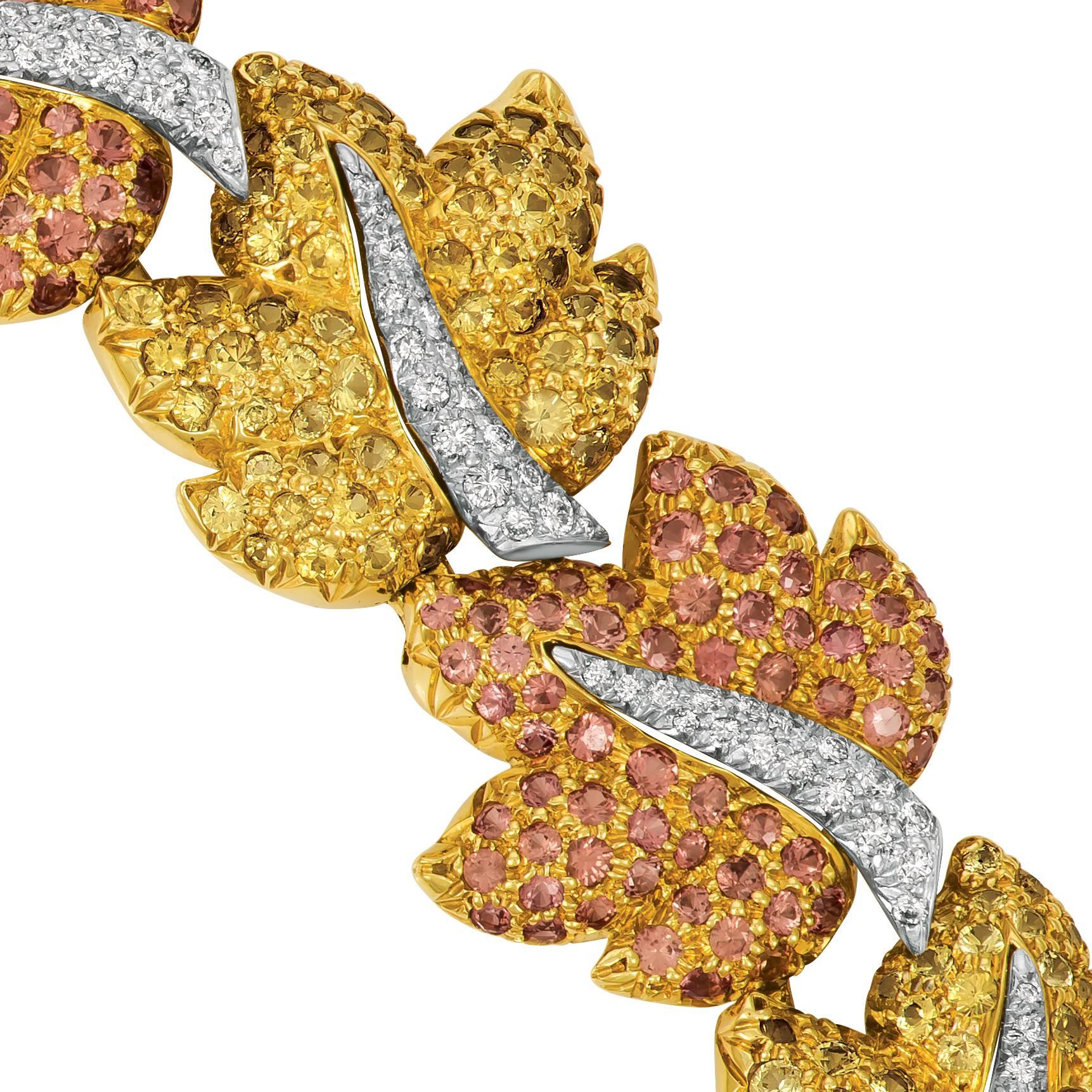 This unique necklace lays on the neck like a perfect garland of autumn leaves. The leaves are pave set with 35 carats of bright yellow sapphires and 30.50 carats of warm cognac sapphires. The center of each leaf is pave set with diamonds, totaling