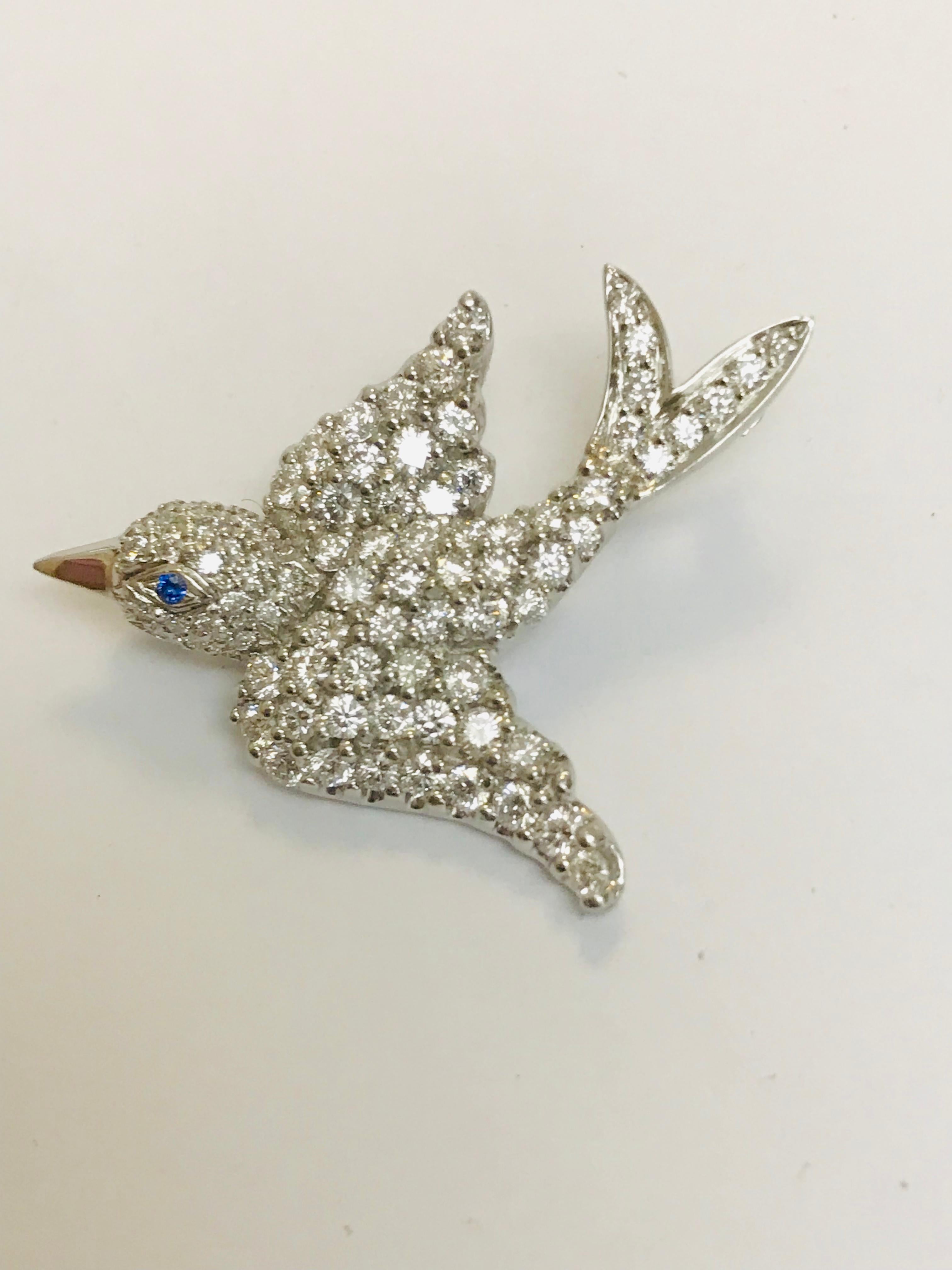 This bird in flight brooch, designed and created by Jean Vitau, is beautifully crafted in Platinum with 2.30 carats of g+ color VVS clarity diamonds. She has a light blue Sapphire for her eye. This brooch can be altered to be worn as a pendant as
