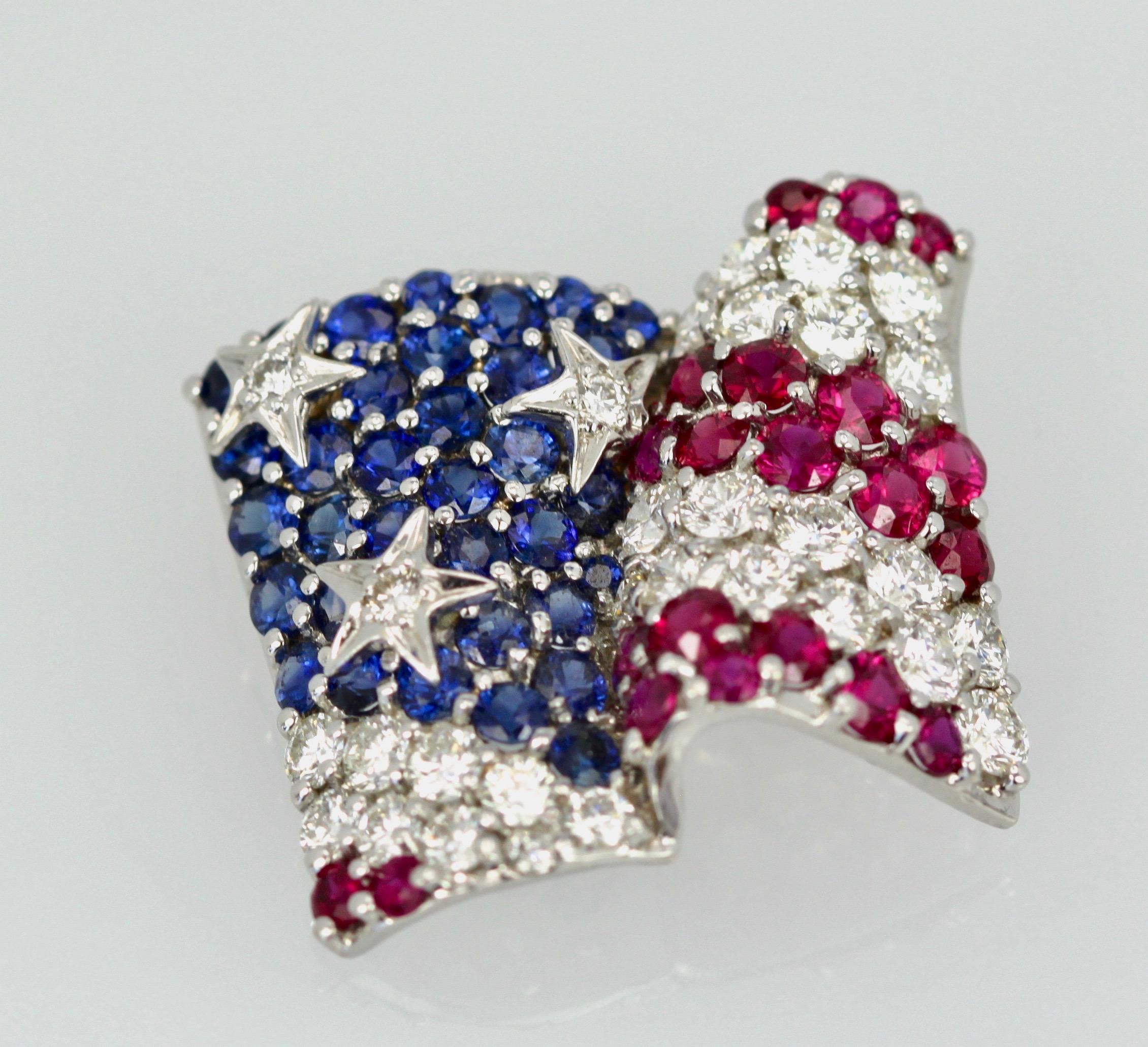 This iconic waving flag brooch is the most recognized piece by famed designer Jean Vitau. This brooch is absolutely gorgeous. The Diamonds are color grade F and clarity is VS.  The Sapphires are translucent and deep blue the Rubies are bright red