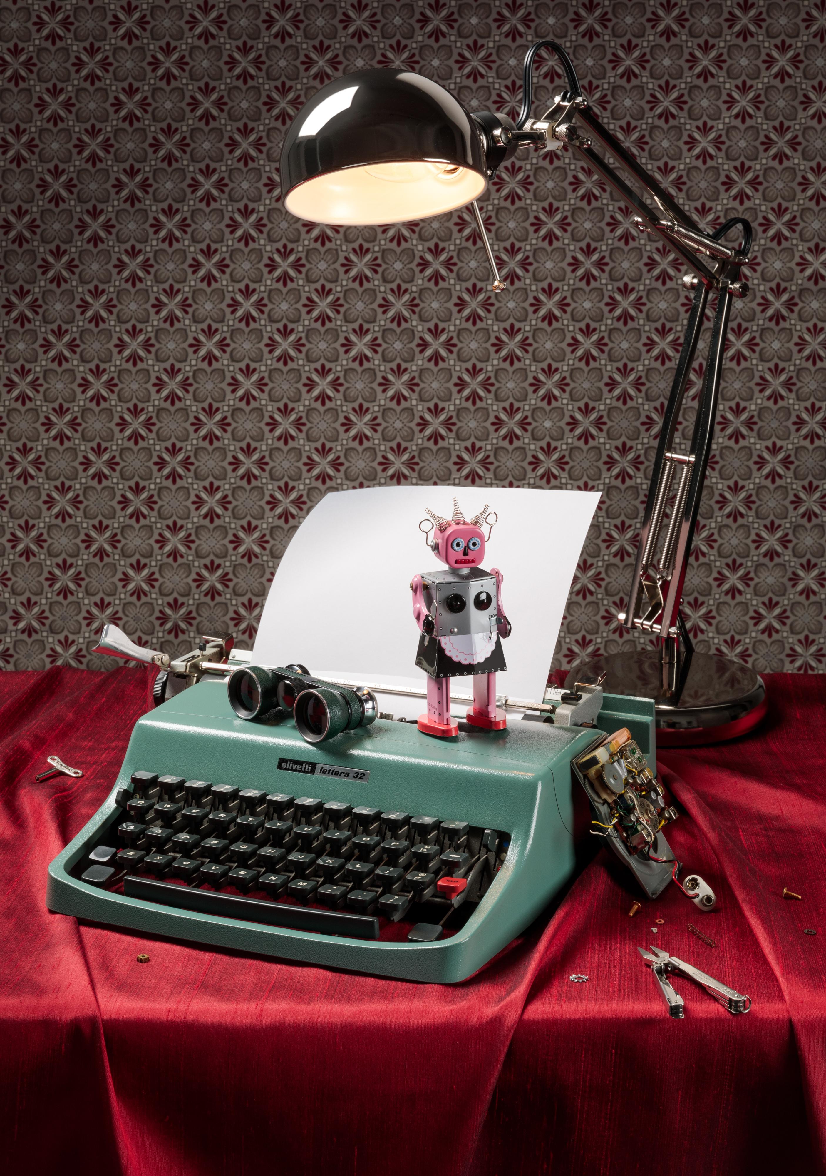 Jeanette May Still-Life Print - “Still Life with Robot” Contemporary Still-life Photo with Vintage Typewriter