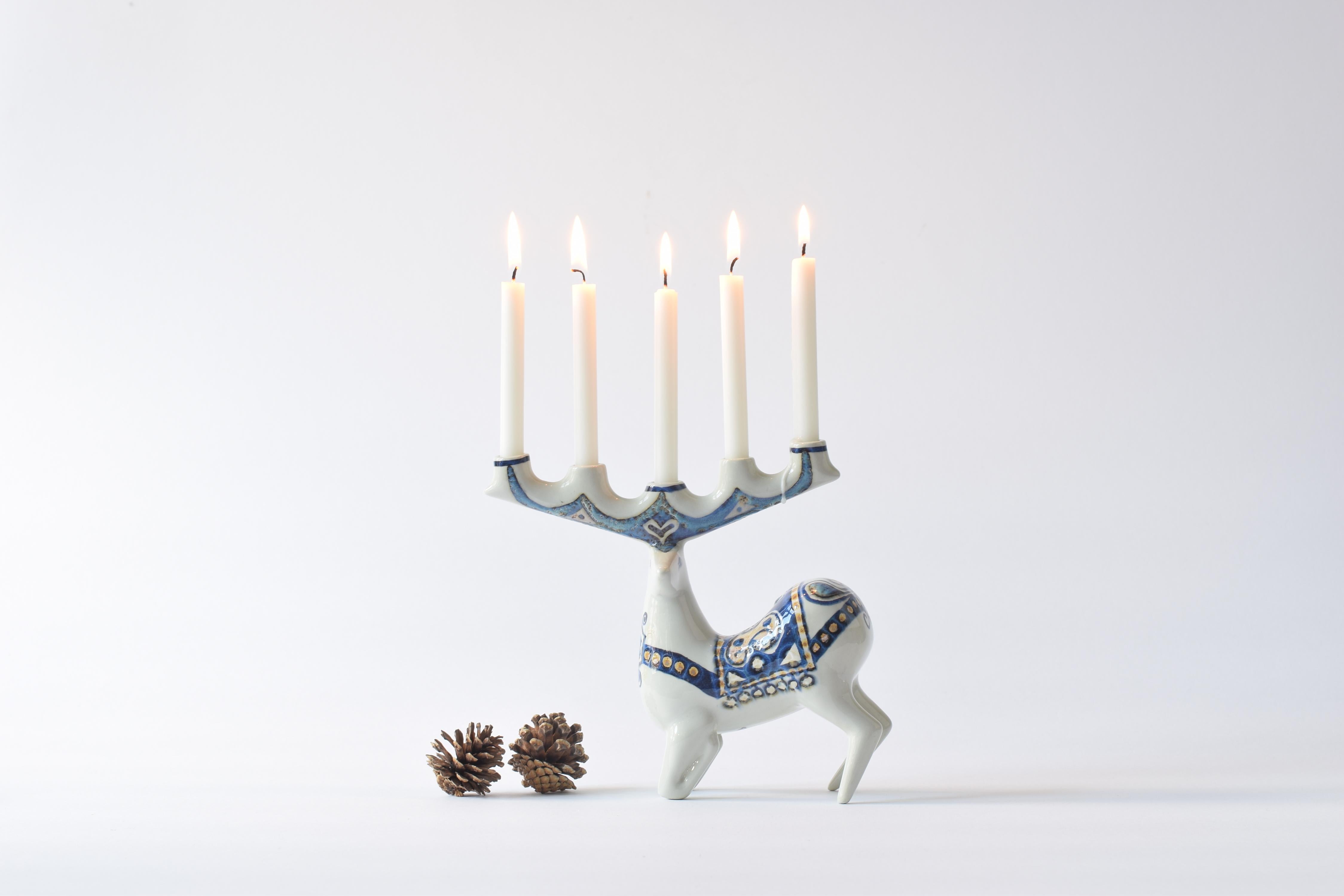 Rare deer figurine candelabra by Jeanne Grut (1927-2009) for Royal Copenhagen. Designed in 1969 and manufactured in the 1970s.
The candelabra is for five small slim candles. 

The candelabra has a handpainted decor which includes abstract flowers