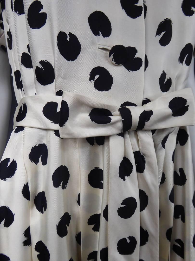 Circa 1960

France

Silk dress with black polka dots on a white background accompanied by a similar bow belt and fringed pans, by the Jeanne Lanvin House directed by Antonio Castillo and dating from the 1960s. Front closure by three buttons in the