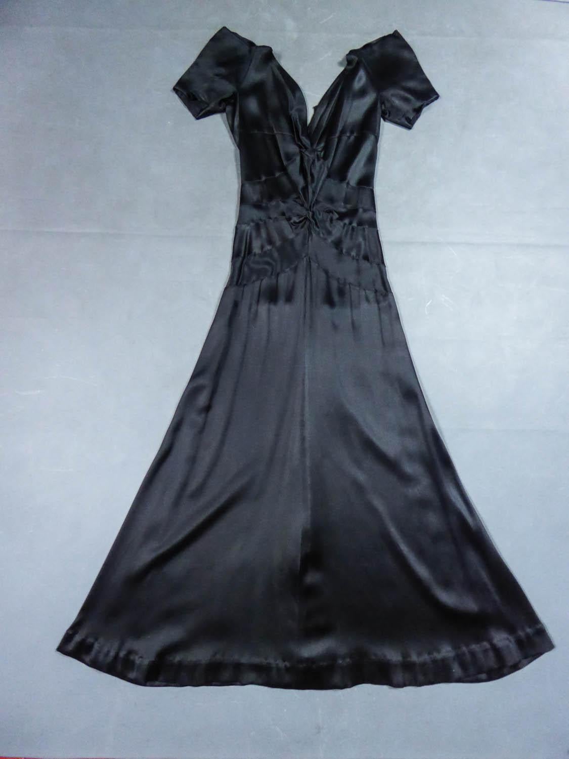 Circa 1935
France

Evening dress in Duchess black satin from the famous french Couture designer house Jeanne Paquin and dating back to the 1930s. Typical cut in bias of this period by hand-stitched panels celebrating a slender and glamorous