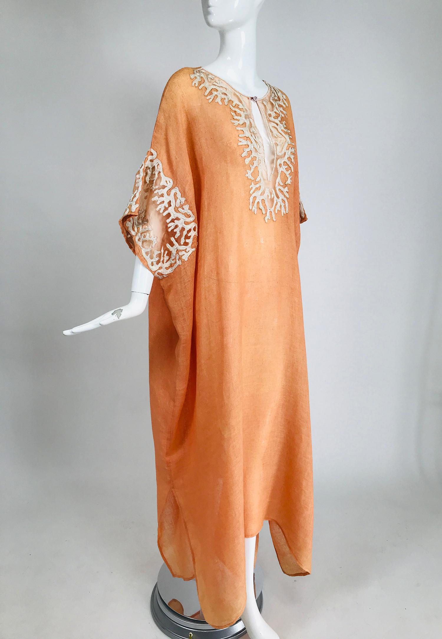 Jeannie McQueeny coral 100% loose weave linen caftan with white coral design appliques that are embellished with white beads at the neckline and arm openings, the appliques are interspersed with sheer organza in coral. The neckline is outlined with