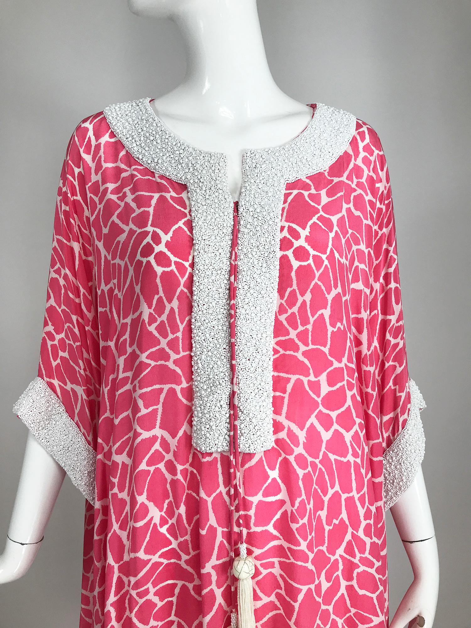 Jeannie McQueeny pink and white silk, heavily beaded caftan, hidden laced front with bead tassel cords. This beautiful caftan is perfect for entertaining at home. Pink and white silk print gives a nod to the 70s, the neckline and cuffs are heavily