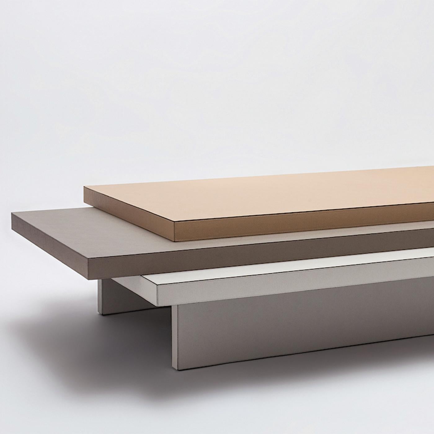 Coffee table Jedha with all structure in solid wood covered with
grained genuine leather, upper top covered in brown leather, middle
table topcovered in grey leather and bottom top and base covered in 
white leather.
