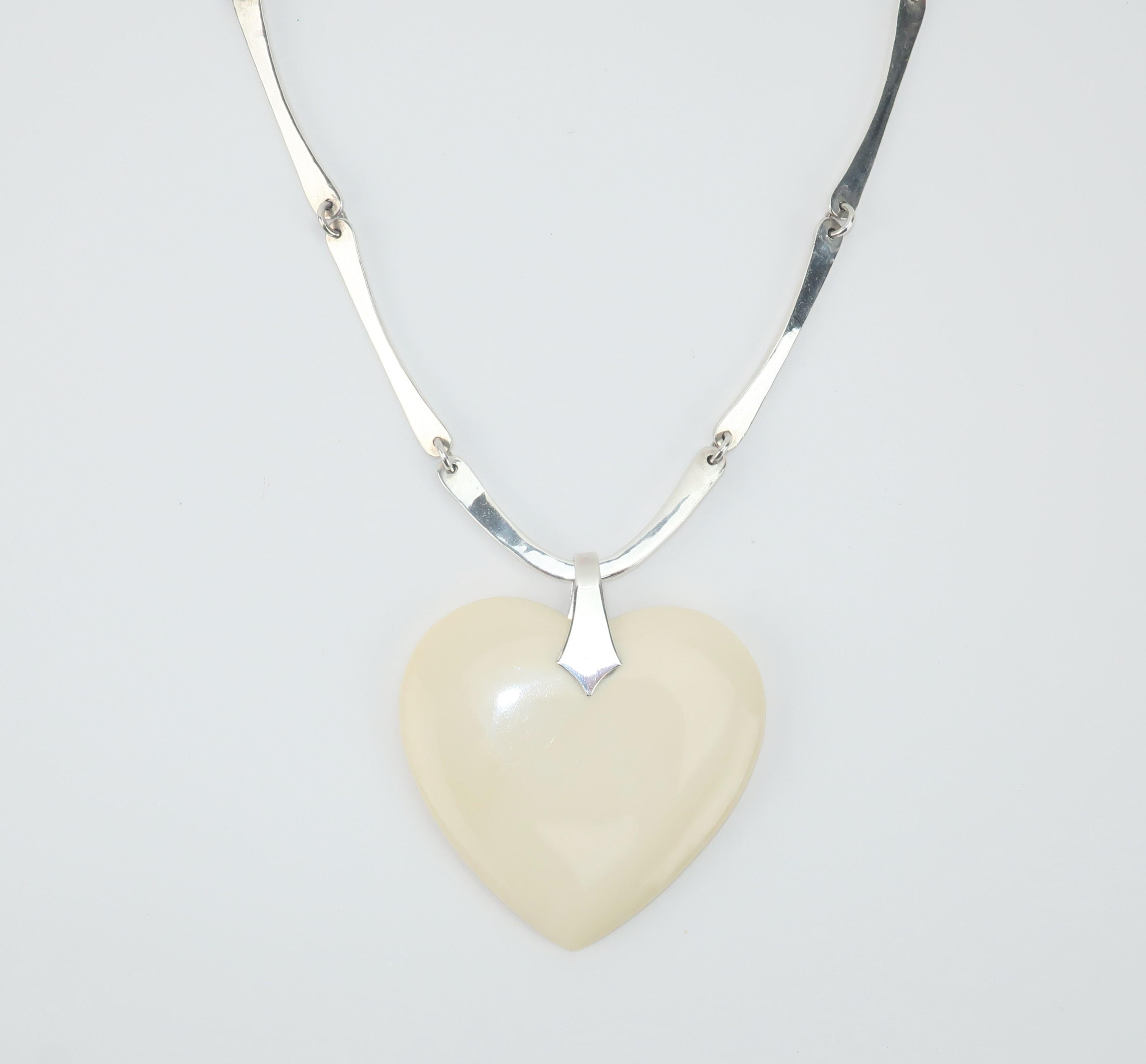 1970's polished bone heart pendant with modernist sterling silver chain necklace by artisan, Jeep Collins.  Collins is the son of Texas handbag designer, Enid Collins, who was famous for her whimsical box handbags.  Created with a hook closure and