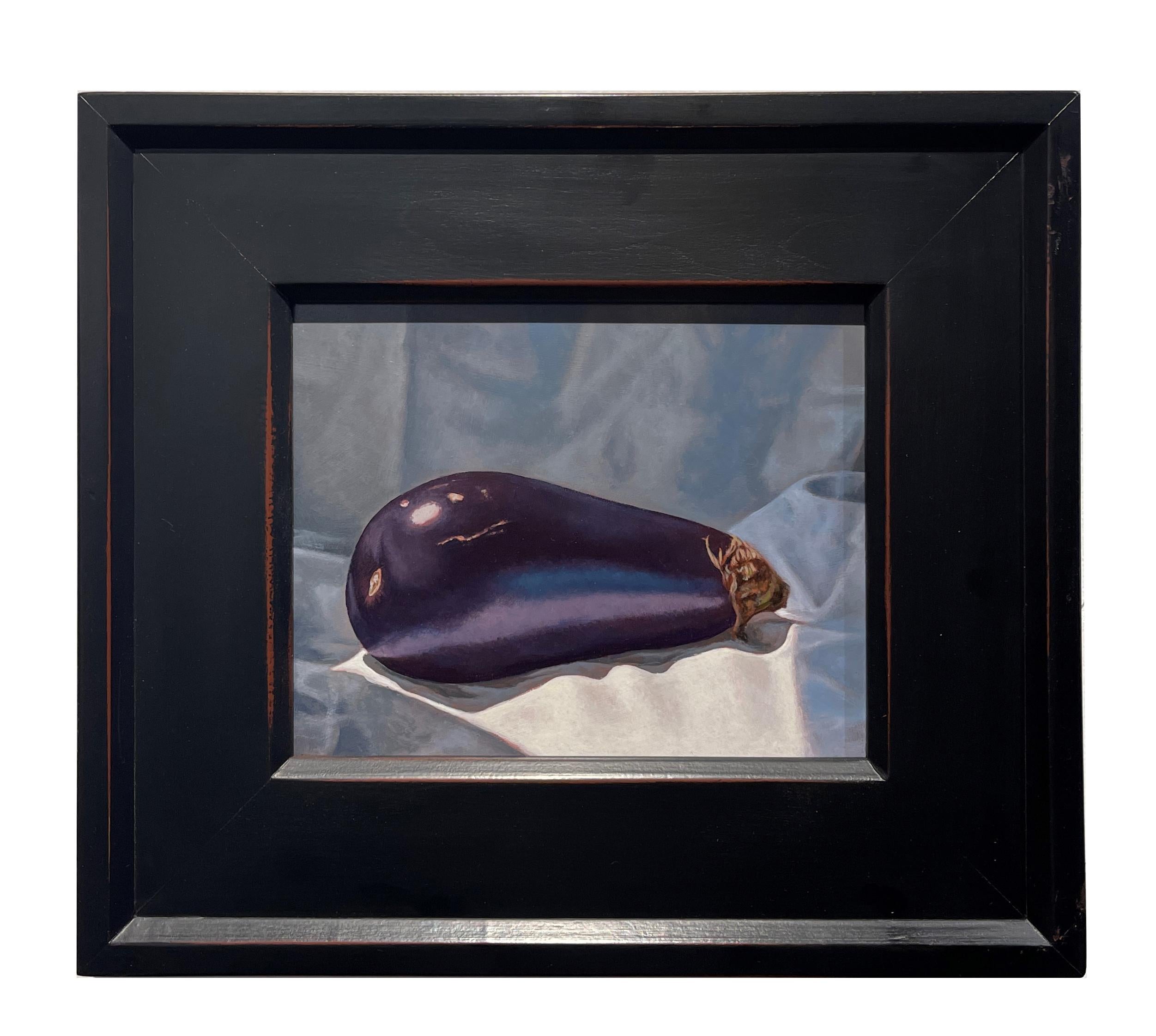 A simple eggplant sits upon a background of draped fabric yet its complexity draws us in to examine the exquisite detail, the softness of the fabric, the surface of the eggplant.  This still life is enhanced by the hand made wooden frame measuring