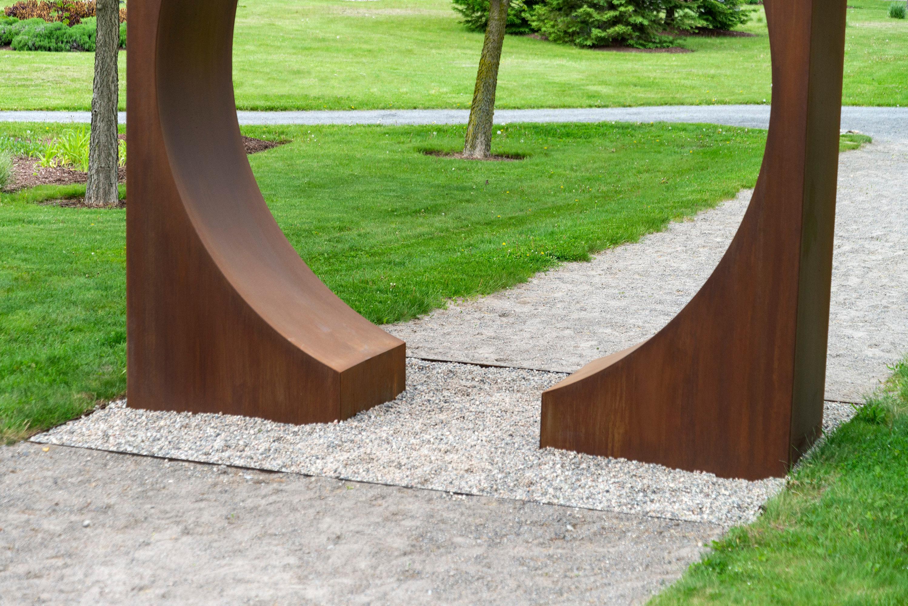 Questa imponente scultura architettonica circolare è stata creata da Jeffrey Gillmor. Grazie a un esperto artigiano del metallo, questo pezzo da esterno, un cerchio tagliato da un quadrato, è forgiato in acciaio acidato e presenta una patina color