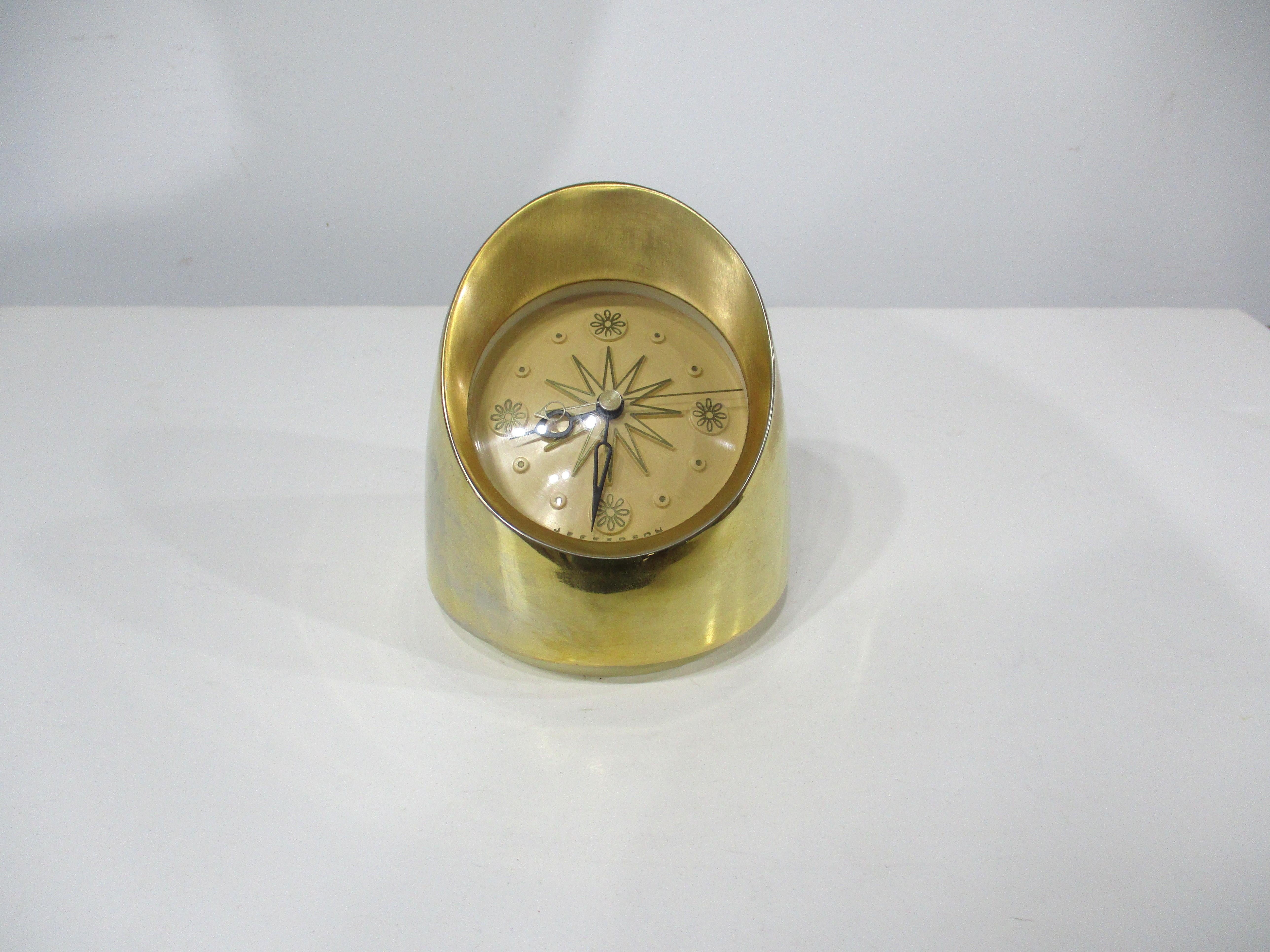A gold plated metal Mid Century table clock with cool hands and a great face all in working order . Manufactured by the Jefferson Clock and Electric company and designed in the manner of George Nelson this is a stylish clock for desk , bedside or