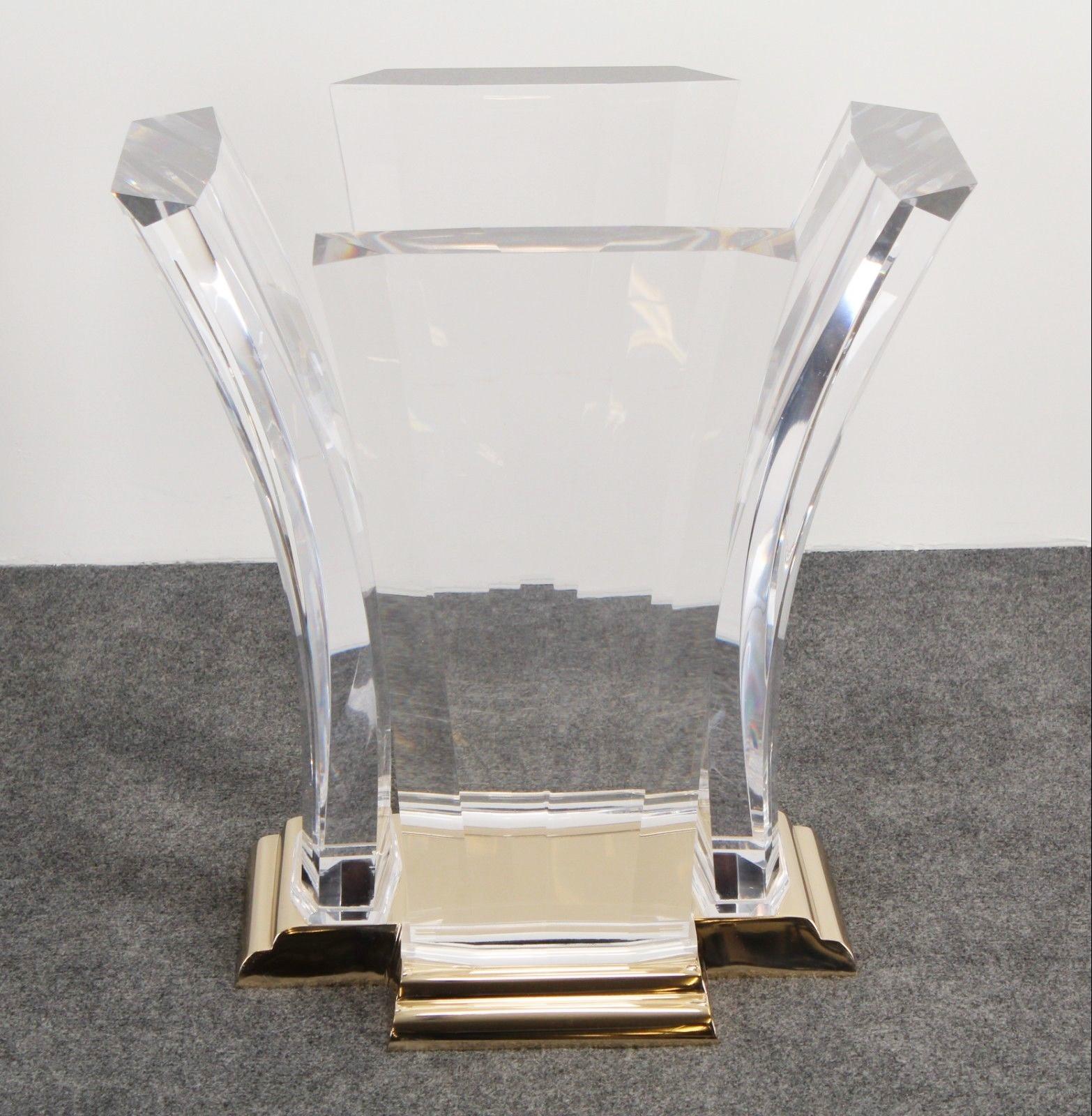 Table à manger glamour conçue par Jeffrey Bigelow pour Spectrum LTD, vers 1976. La base en bronze coulé à volutes est ancrée dans quatre dalles en acrylique coulé à facettes, légèrement arquées, qui soutiennent un plateau en verre. 

Jeffrey
