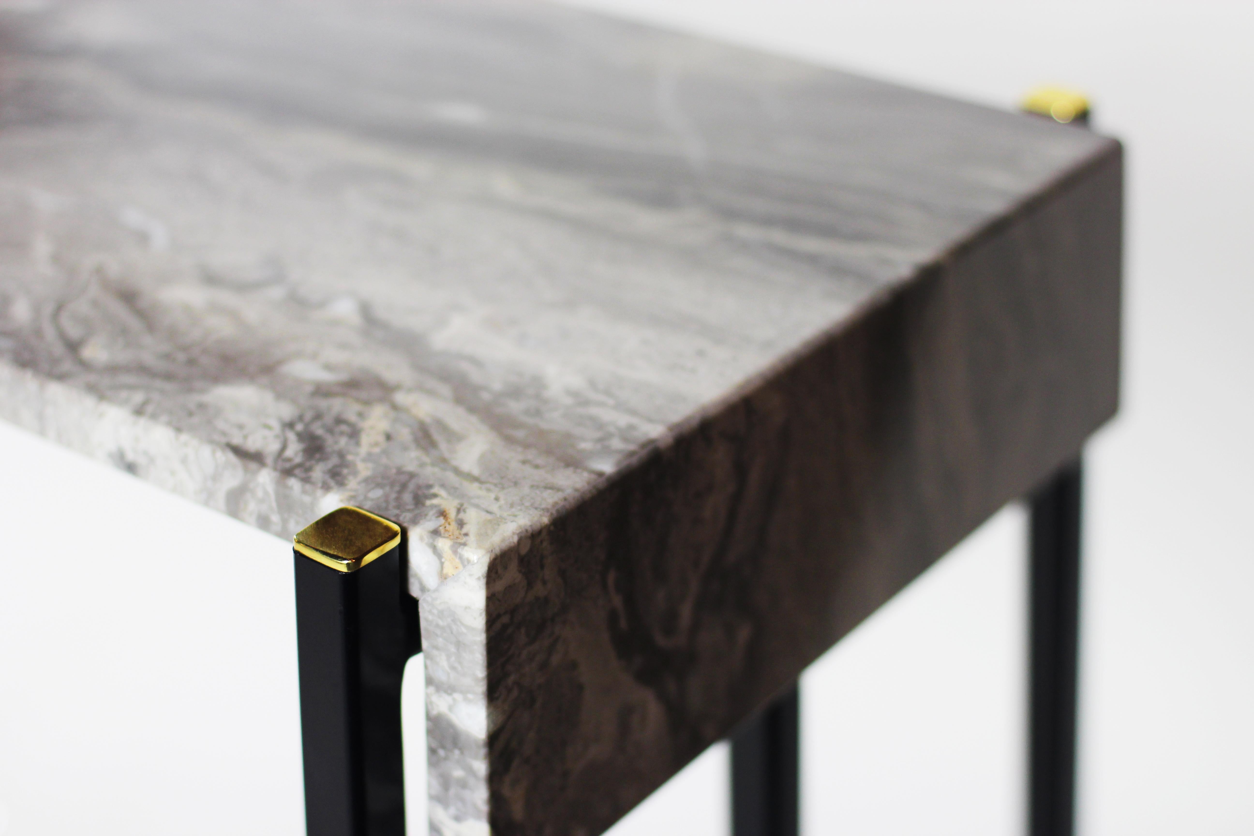 The (wh)ORE HAüS STUDIOS Jeffery console table is made of blackened steel, marble and brass accents. This table is made to order and can, therefore, be customized. As pictured, blackened steel, unlacquered brushed brass lashings, and