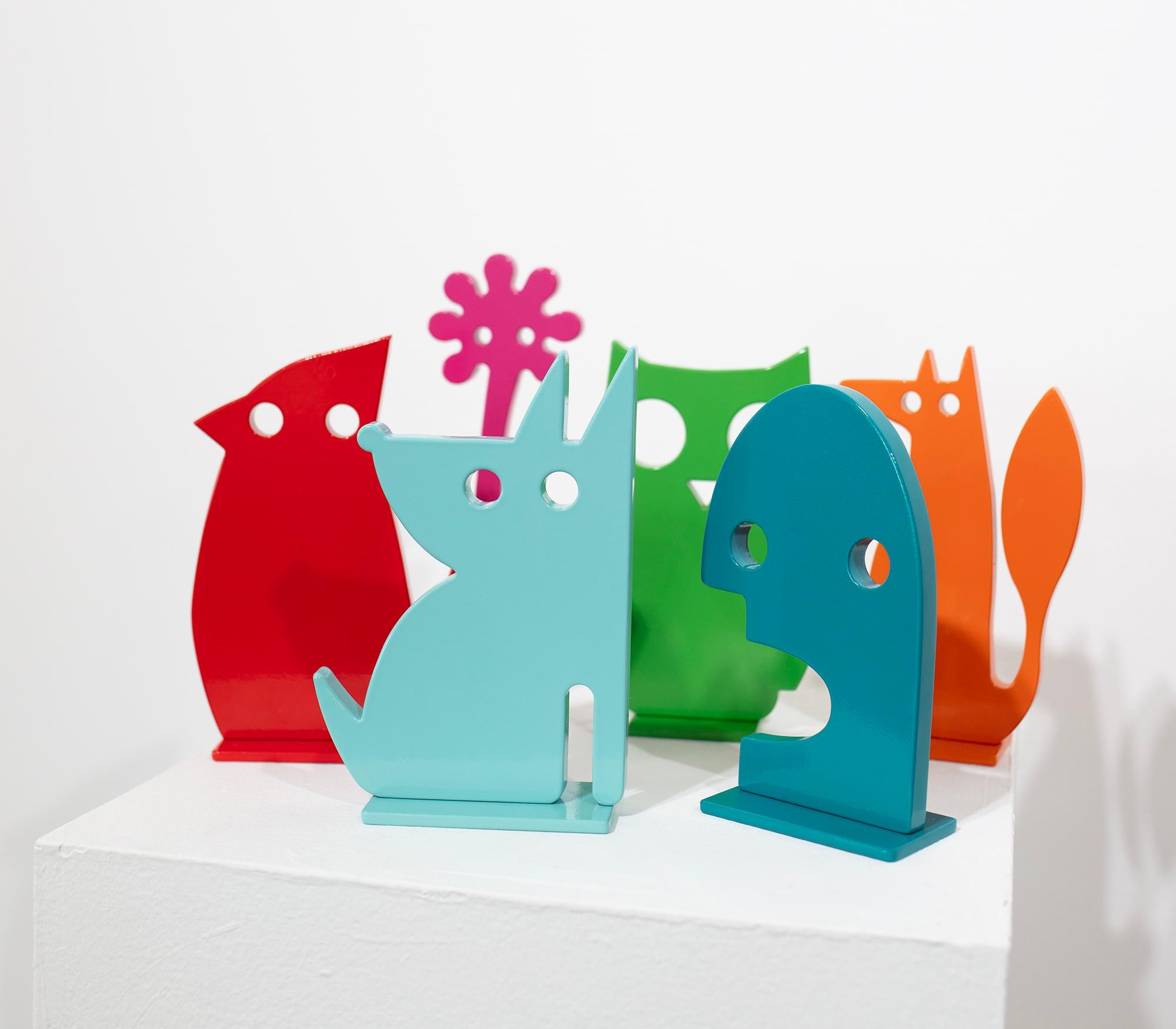 Esta pequeña escultura exenta de una flor rosa magenta abstracta, obra de Jeffie Brewer, está hecha con acero con recubrimiento de polvo. La escultura presenta una forma floral simplificada con dos ojos circulares recortados en medio de los pétalos