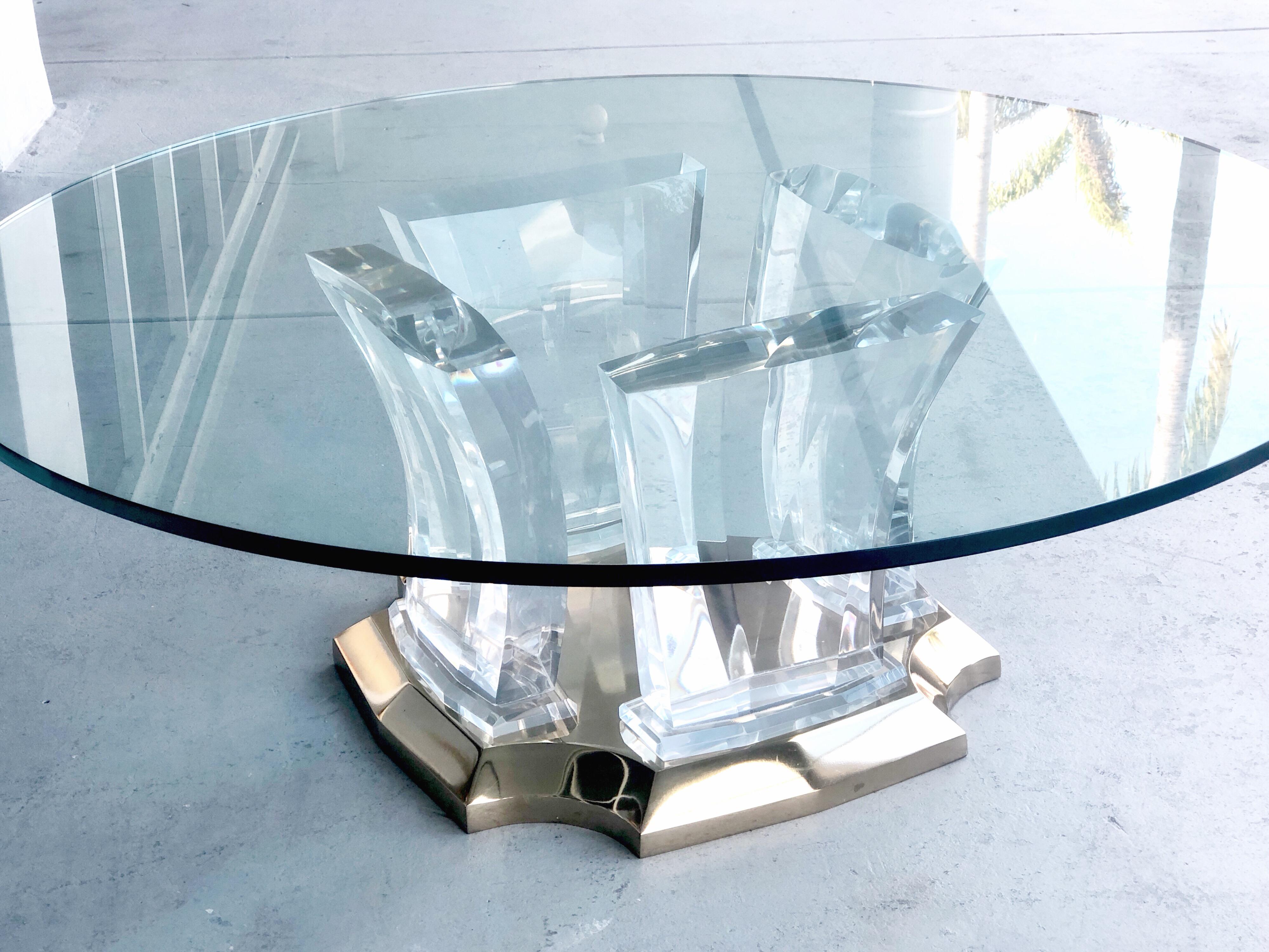 A Jeffrey Bigelow coffee table. the thick, solid and faceted elements rest on a a solid brass base. Round glass top but could use a square or rectangular top.
