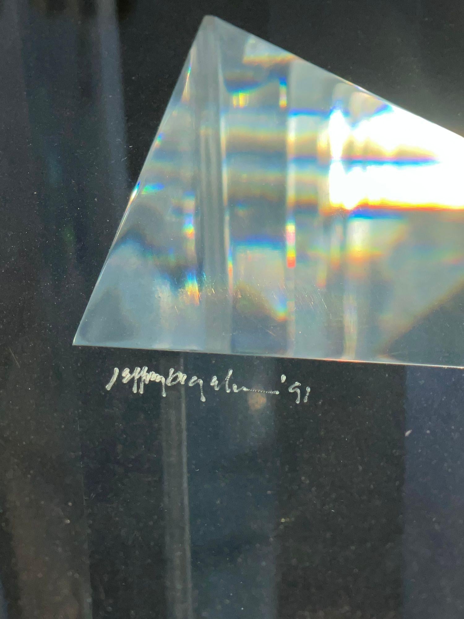 A striking signed Jeffrey Bigelow dining table, model “Towers”, crafted in 1991. The table features a monumental sculptural base composed of geometric acrylic towers rising from a bronze platform, supporting a thick beveled glass top with a