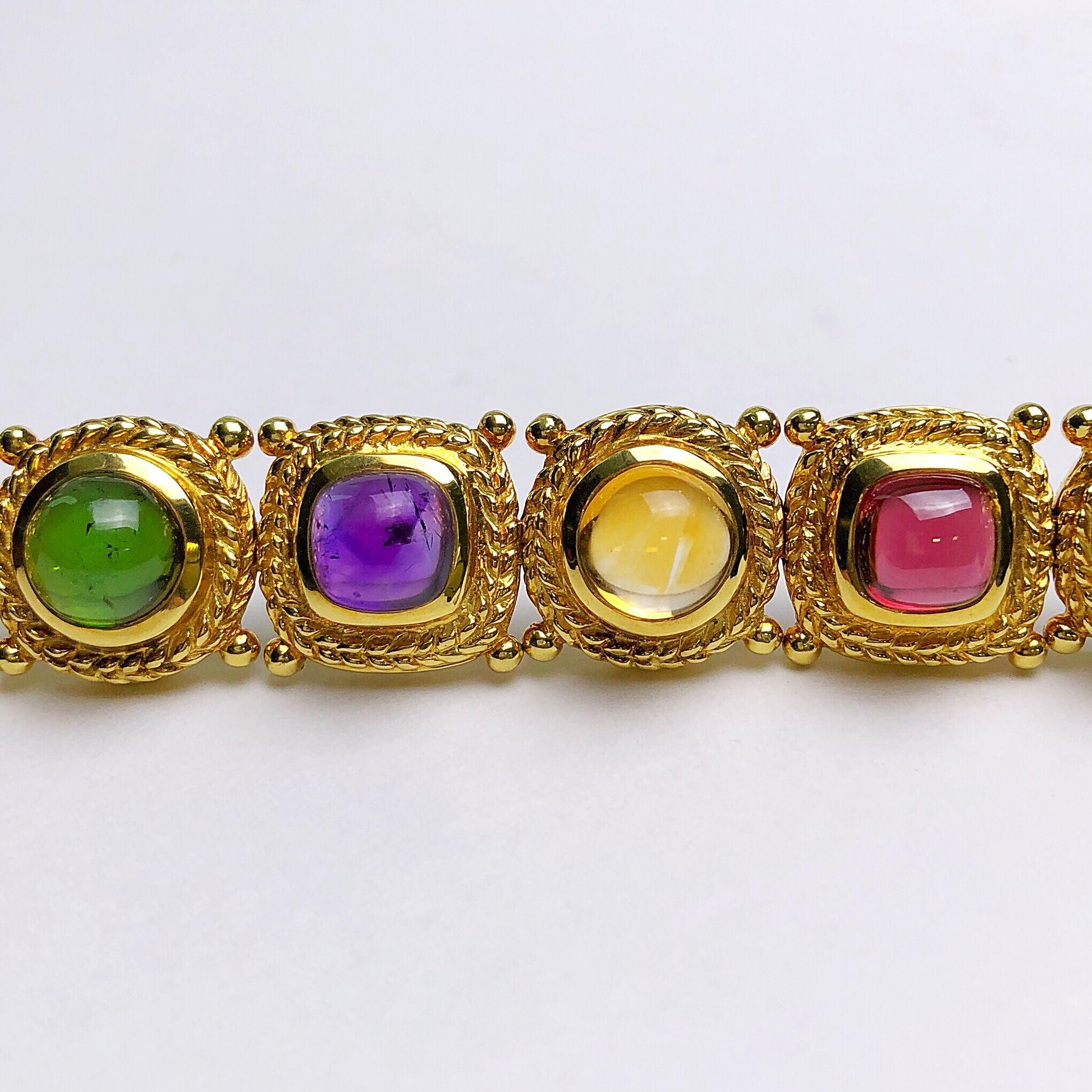 Alternating round and cushion shape semi precious cabochon gemstones are set in 18kt yellow gold with a rope detail effect. Each stone is set in its own section which have been linked together making the bracelet semi-flexible. 
The 10 stones