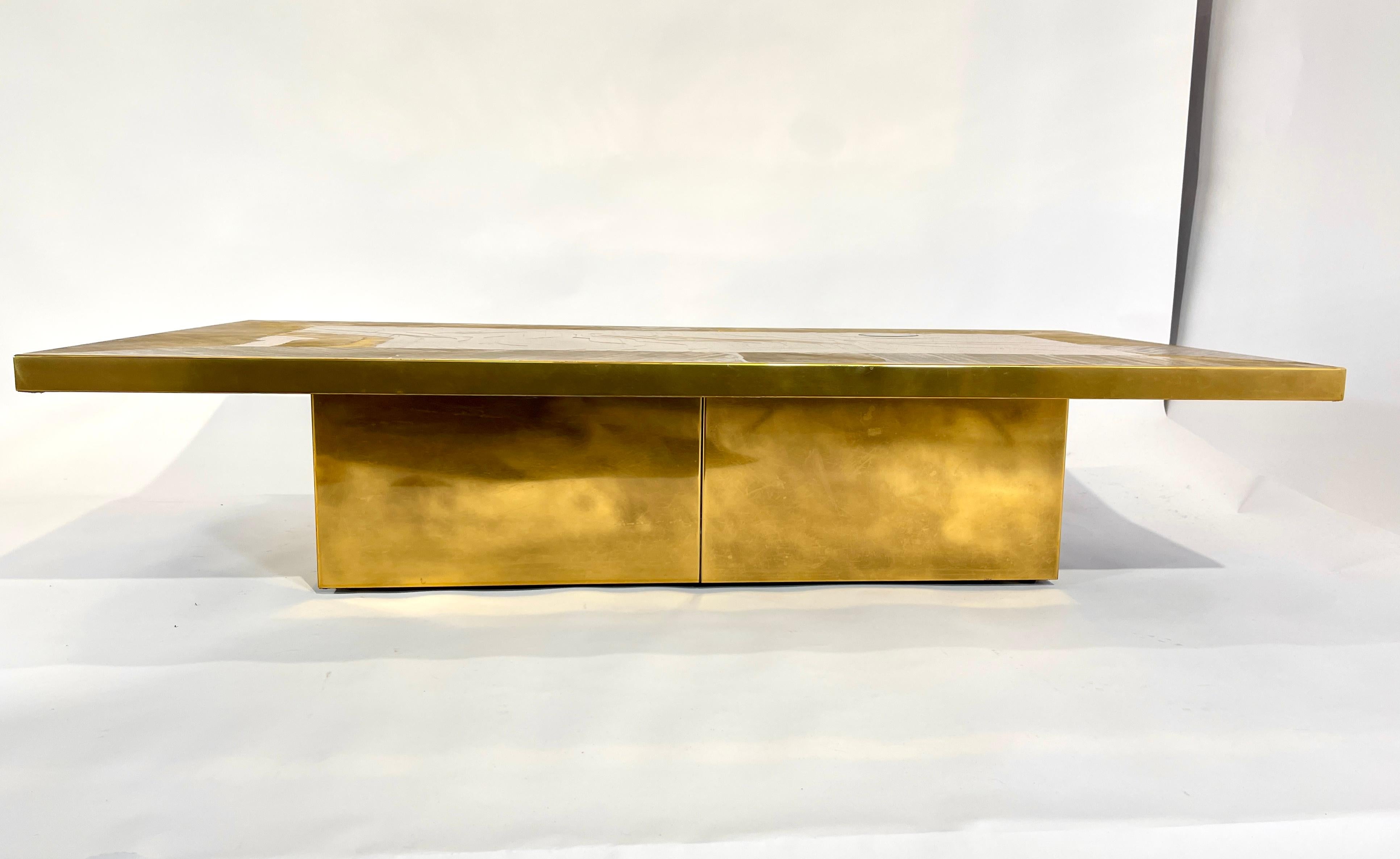 Engraved etched brass coffee table designed by Nadie Jenatzy in 1970, with 1 agate stone top. This furniture has a New refresh, new varnish and polish.
Signed by the Artist.
Nadie Jenatzi (1943-2004) is the wife of Armand Jonckers and the mother of