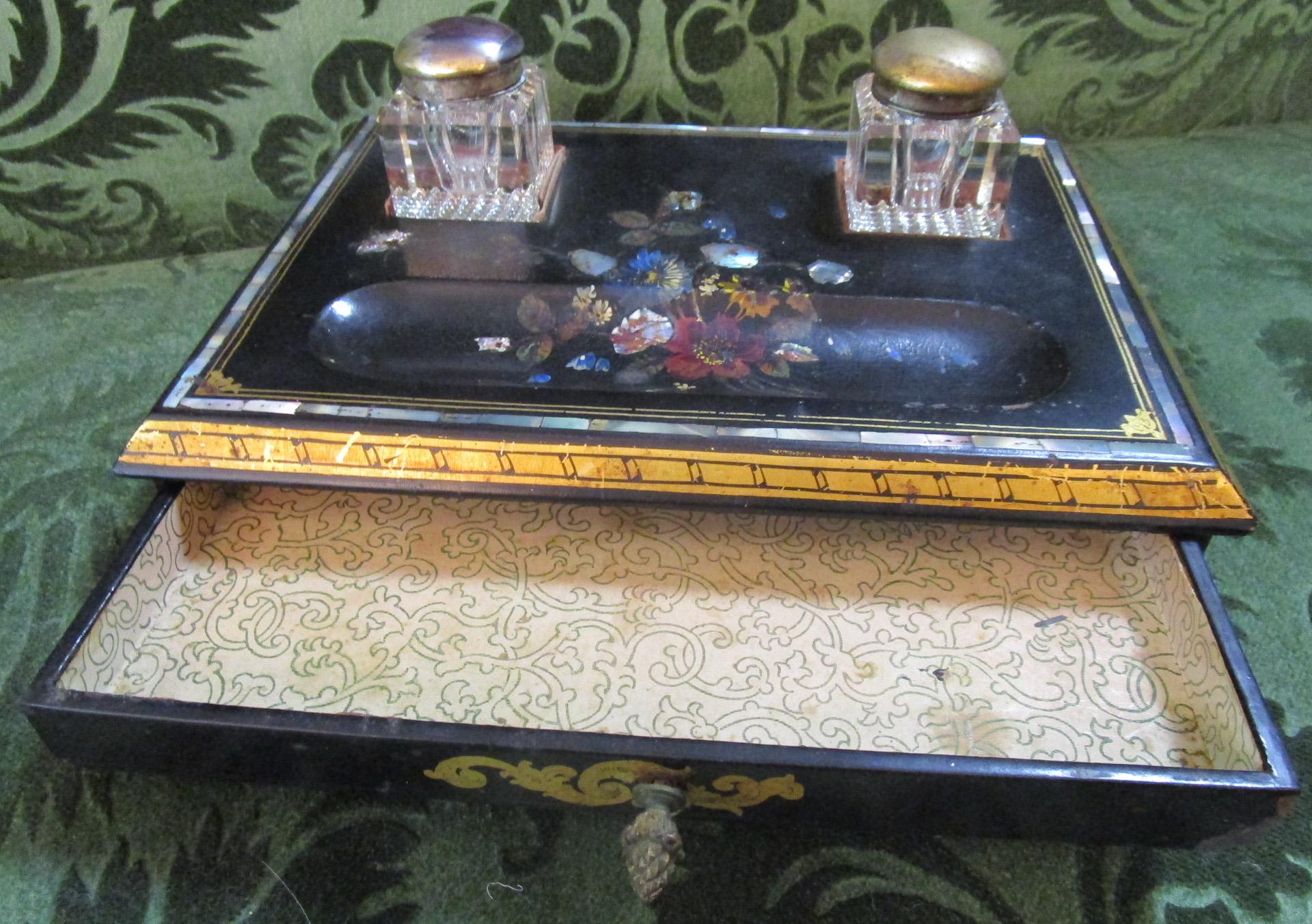 This high quality Papier-Mache desk set is beautifully hand painted in a floral motif and features inlaid mother of pearl and the original pair of cut glass inkwells with brass tops. The very special feature that I have never seen before in an