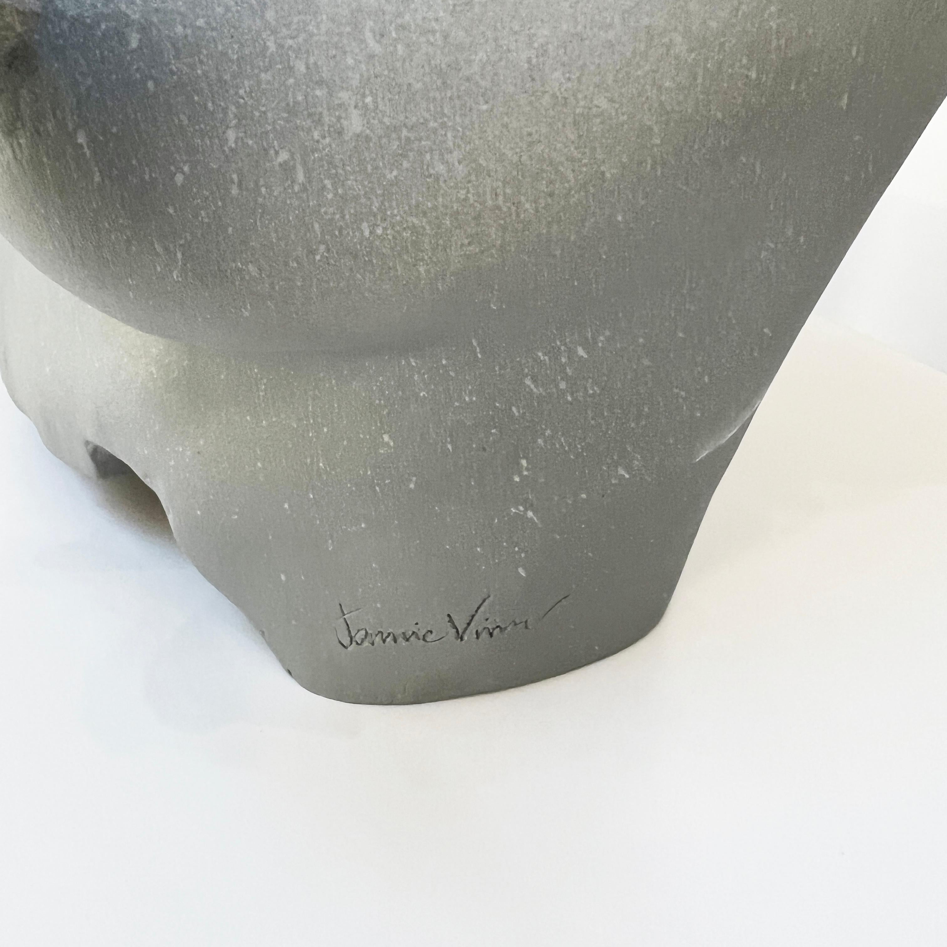 This ethereal freestanding sculpture measures 13 inches high and 16 inches wide and 7 inches deep. The artist signature is hand carved into the side of the sculpture. It is fired in a light grey matte glaze which lends a soft, elevated finish. The