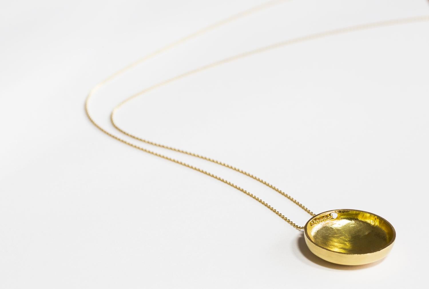 Ciondolo a forma di disco scolpito in cera e fuso in oro (con una finitura a specchio) su una catena d'oro da 34 pollici con chiusura a moschettone.