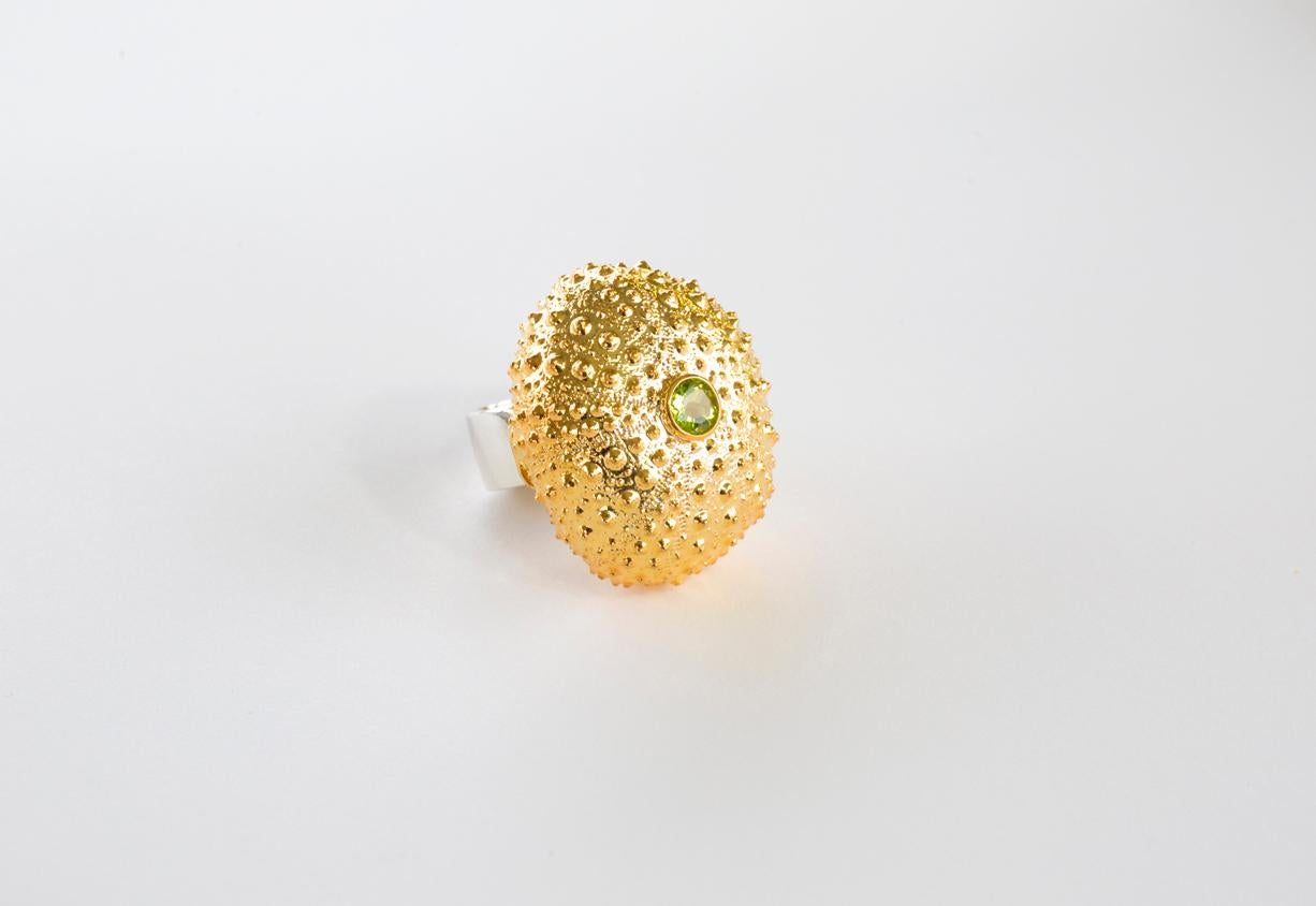 Our Sea Urchin Collection was inspired by our long walks by the sea in Lorient, St. Barth's. This Sea Urchin Ring was cast from nature in 14kt yellow gold.  It has a rosecut peridot gemstone in its center. 

The ring is a Size 7 and may be resized