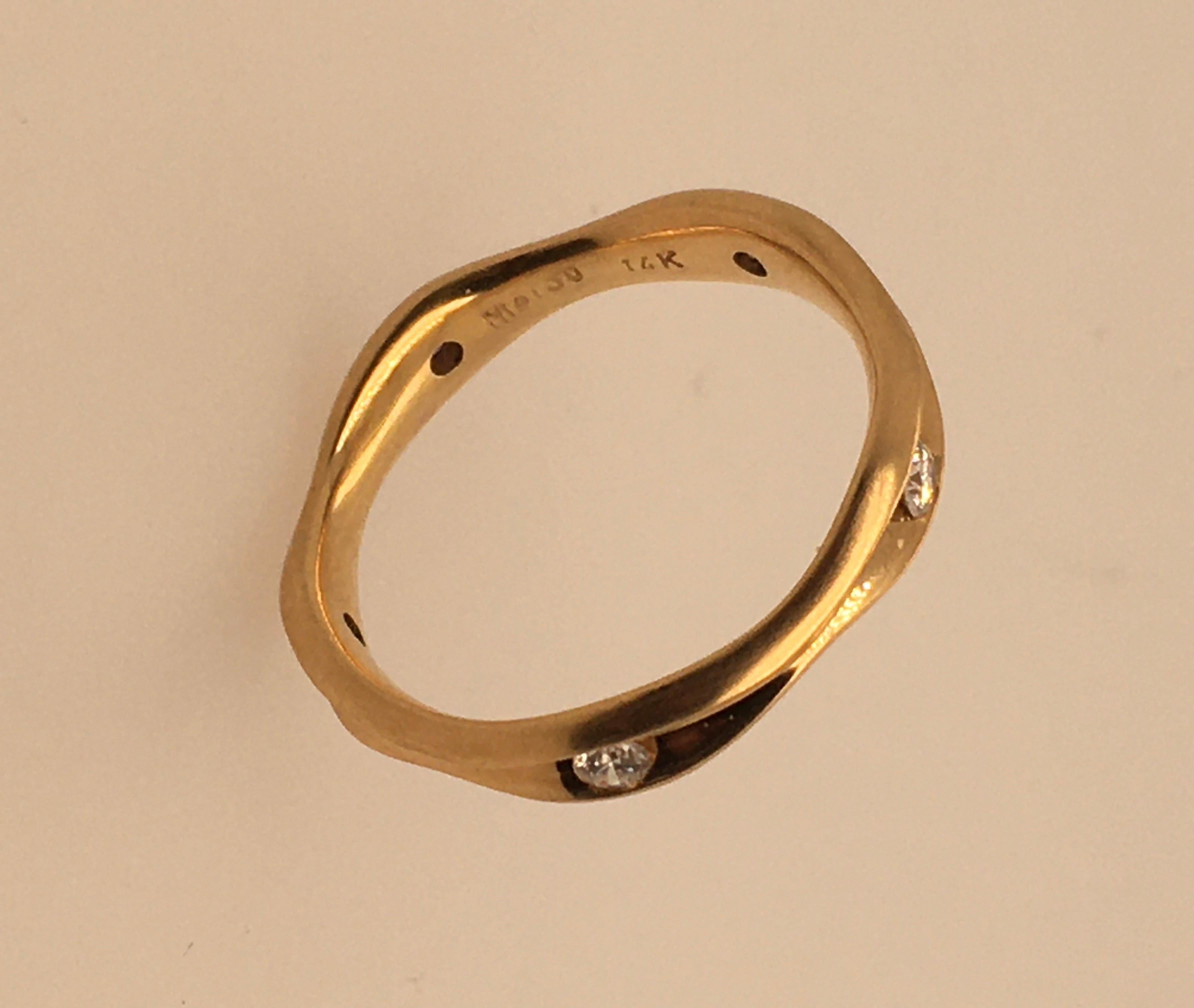 A beautiful 14K satin finish yellow gold wavy ring with 5 diamonds in a channel setting, equi-distance around the band.   Each stone is 045 pts.  / TCW 22.5 pts.  Designer's imprint on interior reads 