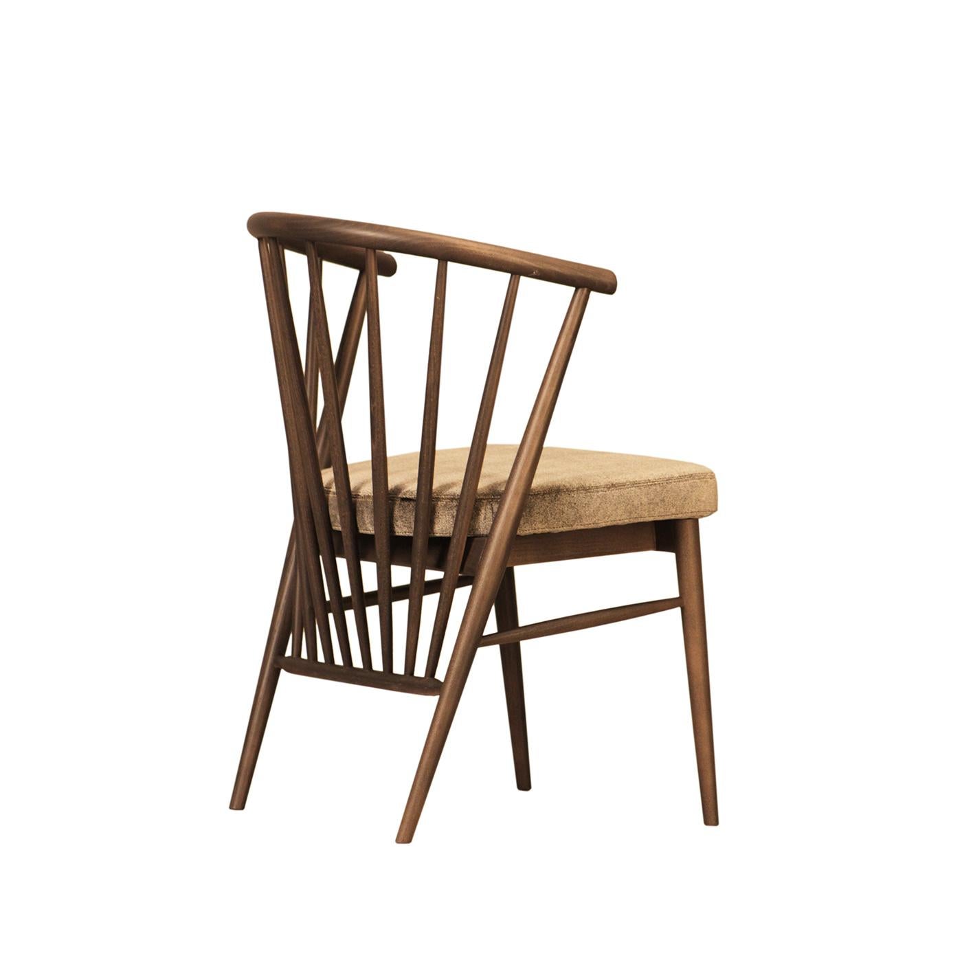 This exquisite chair is marked by an sculptural design that focuses on the harmony between sharp and rounded lines. The ash frame comprises an eye-catching backrest distinguished by radially converging elements oriented downwards and continuing down