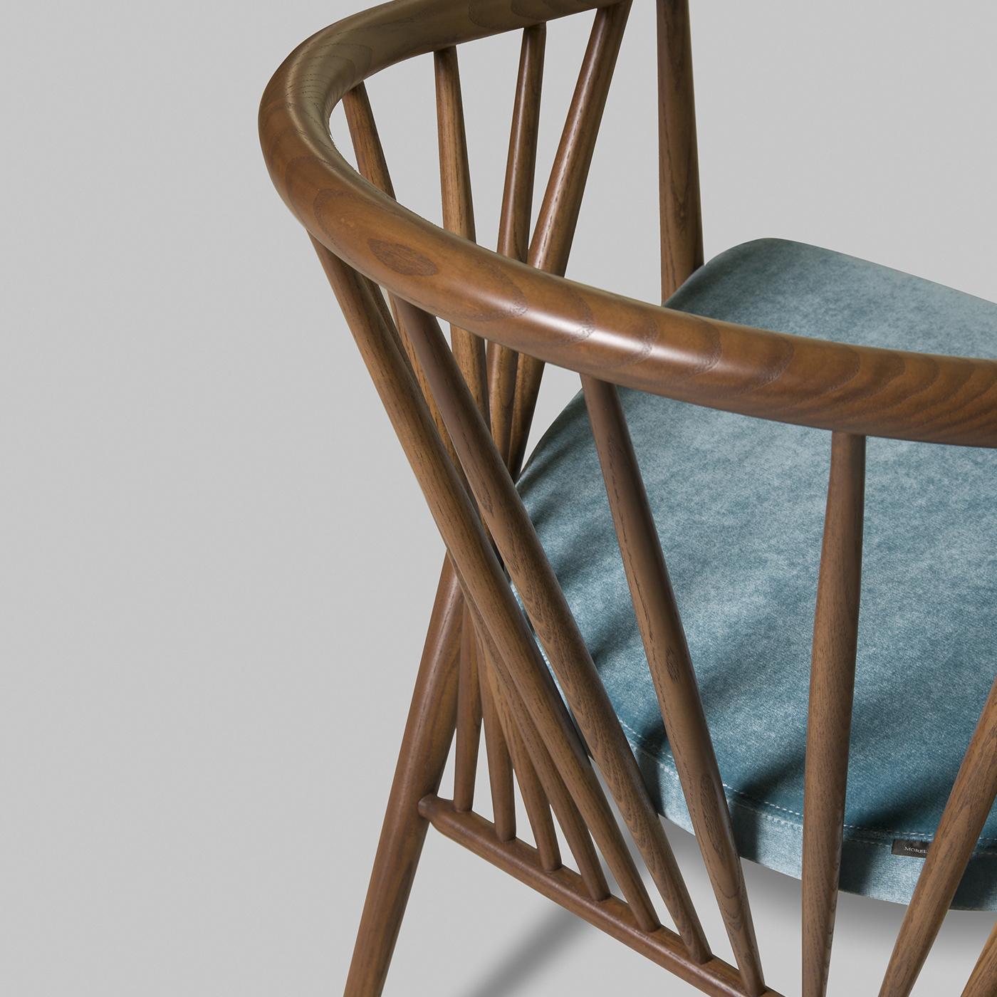 Jenny ist eine originelle Stuhlserie aus massivem Walnuss-Eschenholz mit einem gepolsterten Sitz aus blauem Samt. Dank der eleganten Anordnung der Stangen der gebogenen Rückenlehne ist die Struktur besonders leicht und luftig, perfekt, um jedem Raum