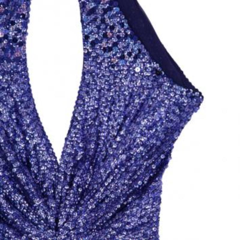 Issue de la collection automne/hiver 2010, cette robe Jenny Packham est un paradis d'embellissements. Son extérieur chatoyant est décoré de paillettes violettes. La taille est accentuée par des ruchés, combinés à un profond col licou et à un dos