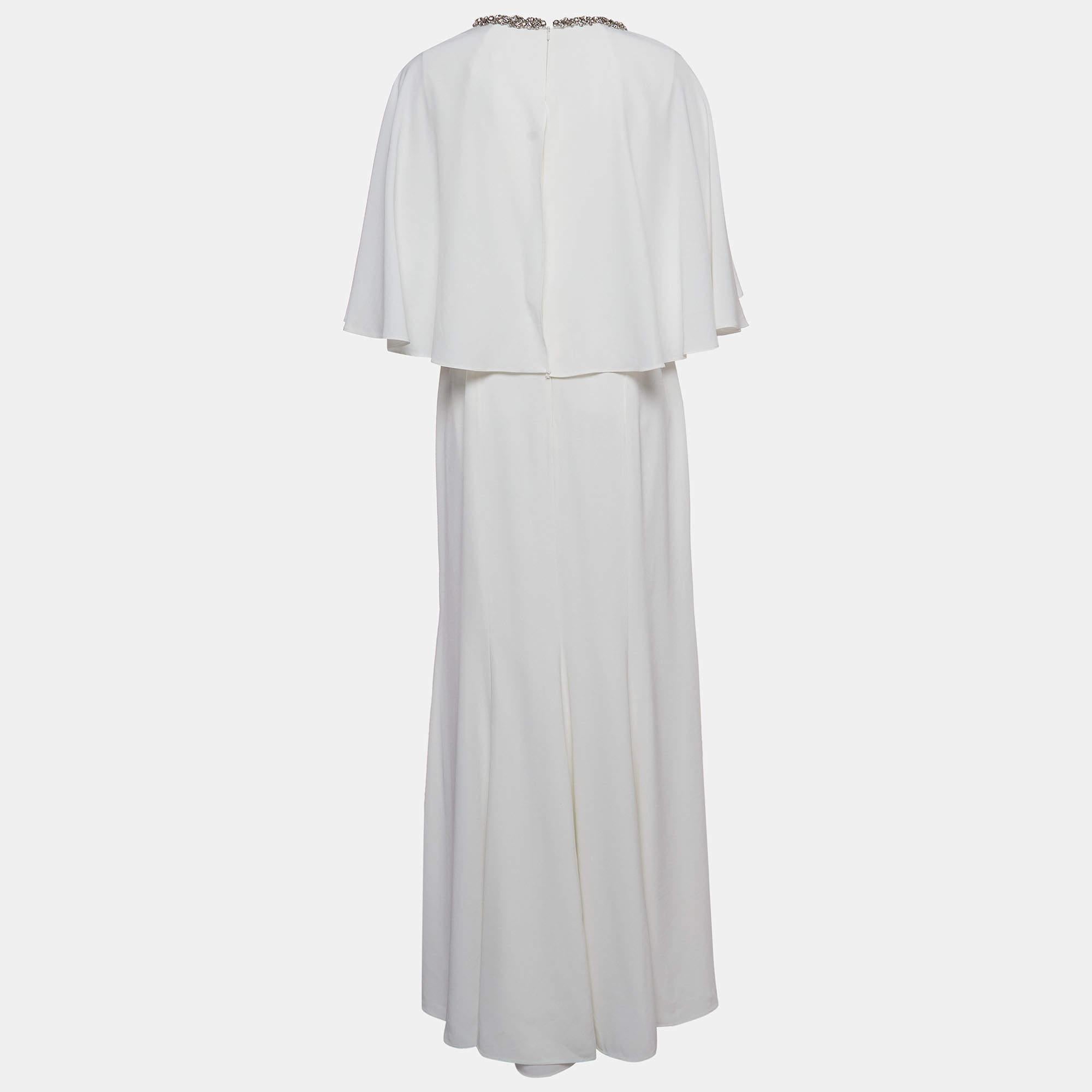 La robe de mariée Jenny Packham est un chef-d'œuvre exquis, doté d'un luxueux tissu de satin blanc qui se drape élégamment. Le décolleté de la robe est orné d'embellissements complexes en cristal, ajoutant une touche de glamour. Ce design intemporel