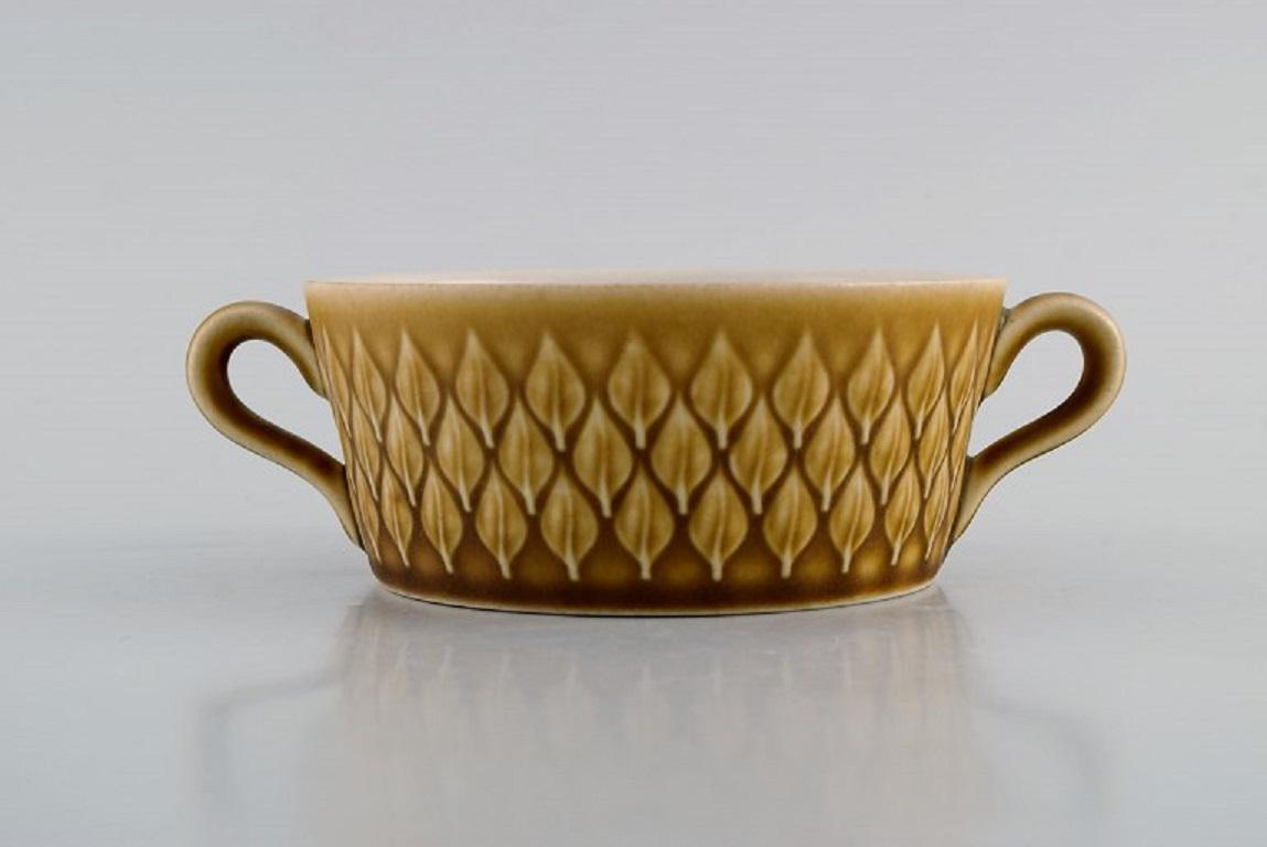 Jens H. Quistgaard (1919-2008) for Bing & Grøndahl. 
Eight Relief bouillon cups in glazed stoneware. Beautiful glaze in mustard yellow shades. 
1960s.
Measures: 11.7 x 5 cm.
In excellent condition.
Stamped.