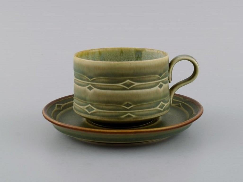 Jens H. Quistgaard (1919-2008) for Bing & Grøndahl. 
Rune coffee service in glazed stoneware for four people. 1960s / 70s.
Consisting of four coffee cups with saucers and four plates.
The cup measures: 8 x 6 cm.
Saucer diameter: 14.5 cm.
Plate