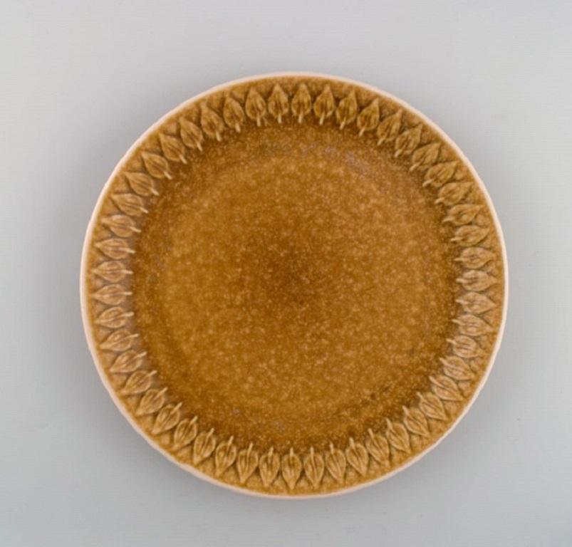 Jens H. Quistgaard (1919-2008) for Bing & Grøndahl. 
Twelve Relief dinner plates in glazed stoneware. 
Beautiful glaze in mustard yellow shades. 1960s.
Diameter: 24 cm.
In excellent condition.
