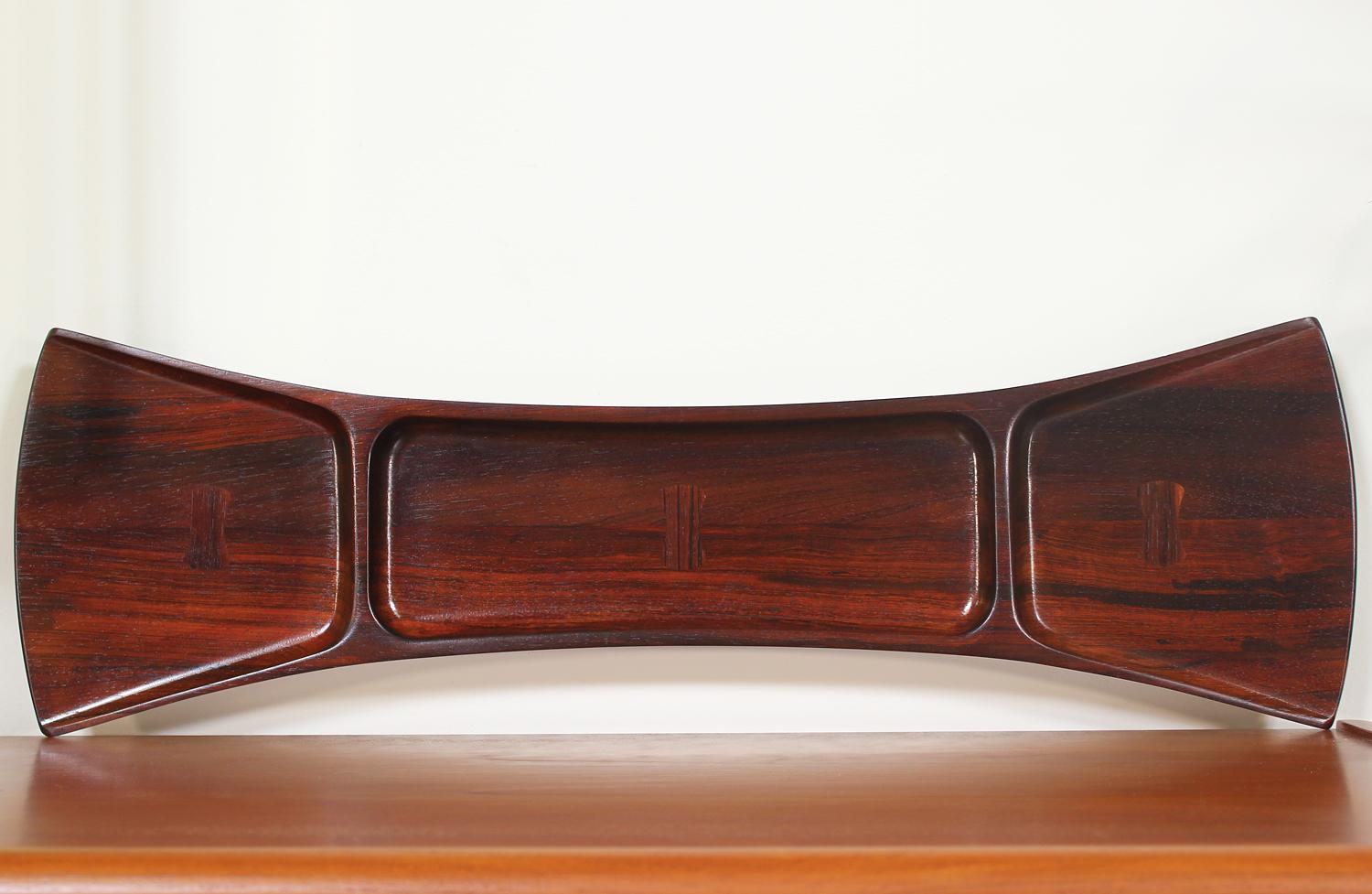 Stylish tray designed by Jens H. Quistgaard for Dansk in Denmark circa 1960’s. Impeccably crafted in palisander rosewood, this sculptural serving tray features a bow tie shape with three divisions adorned with butterfly inlay within each section.