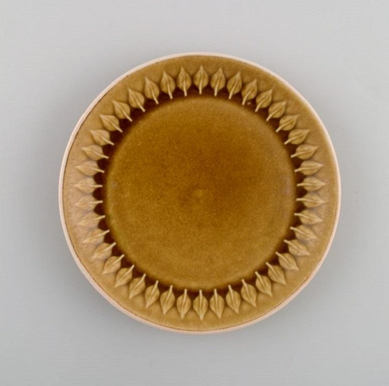 Jens H. Quistgaard (1919-2008) for Bing & Grøndahl / Nissen Kronjyden. 
11 Relief cake plates in glazed stoneware. Beautiful glaze in mustard yellow shades. 1960s.
Diameter: 16.5 cm.
In excellent condition.
Stamped.