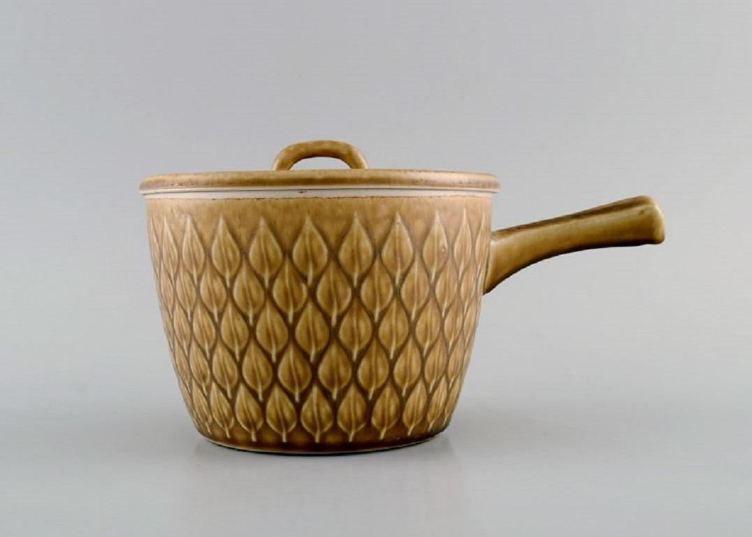 Jens H. Quistgaard (1919-2008) for Bing & Grøndahl / Nissen Kronjyden. 
Relief pot with handle in glazed stoneware. Beautiful glaze in mustard yellow shades. 1960s.
Measures: 20.5 x 11.5 cm.
In excellent condition.
Stamped.