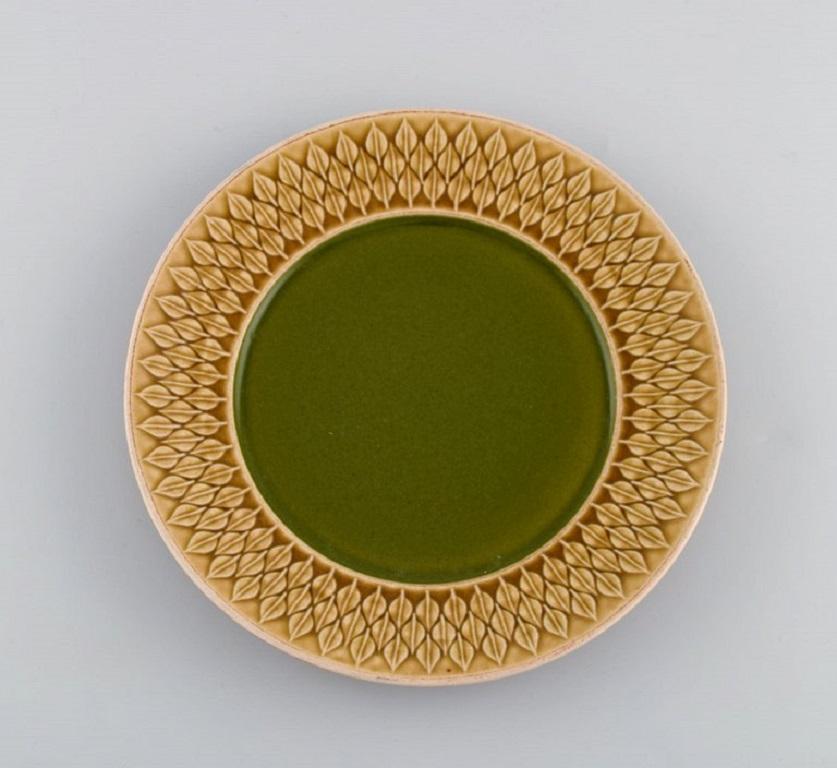 Jens H. Quistgaard (1919-2008) for Bing & Grøndahl / Nissen Kronjyden. 
Twelve relief lunch plates in glazed stoneware. 
Beautiful glaze in mustard yellow and green shades. 1960s.
Measurs: diameter: 21 cm.
In excellent condition.
Stamped.