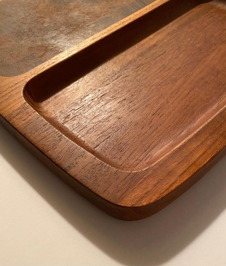 A divided teak wood tray with an end-grain teak cutting surface and a recessed section, designed by Jens H. Quistgaard for Dansk. Branded 