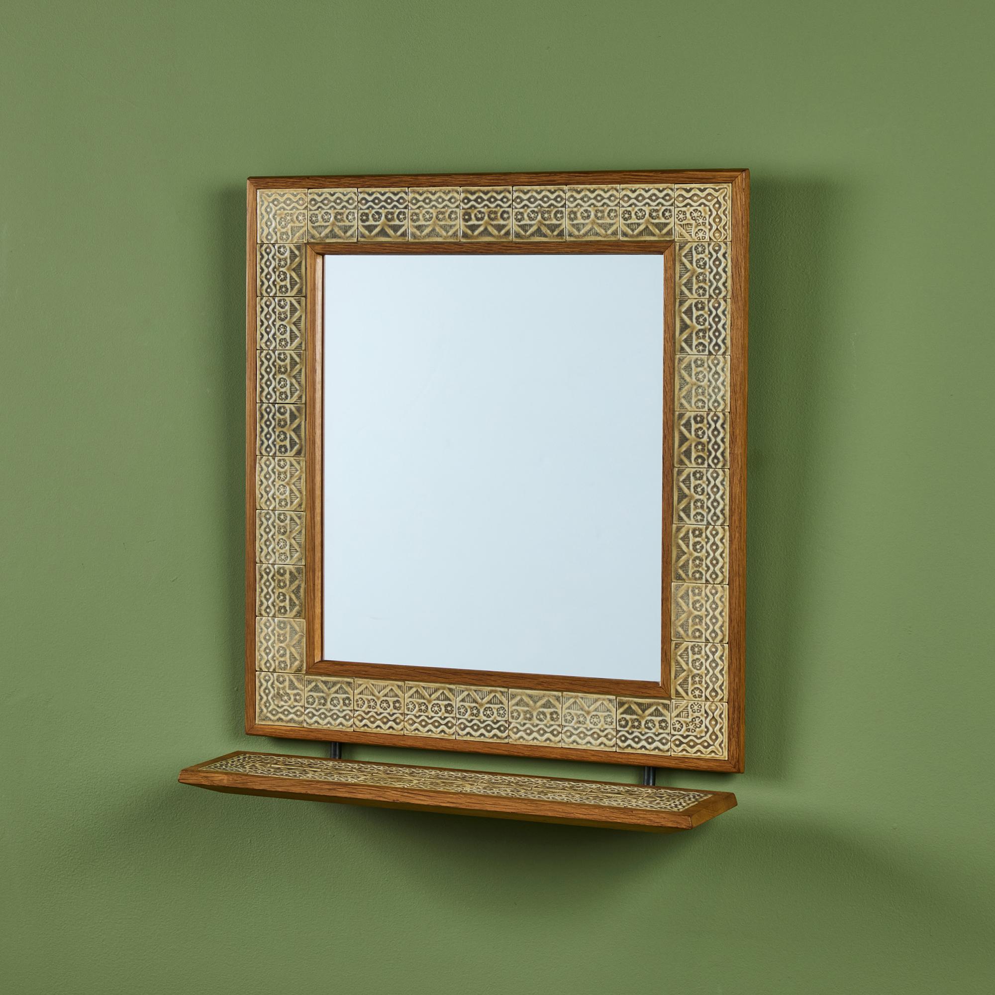 Wall mirror by Jens H. Quistgaard for Richard Nissen, c.1960s Denmark, features a rectangular hand-oiled oak frame with tile inlay. The mirror also showcases a tile shelf, perfect for a small vase or key dish.

Dimensions
18