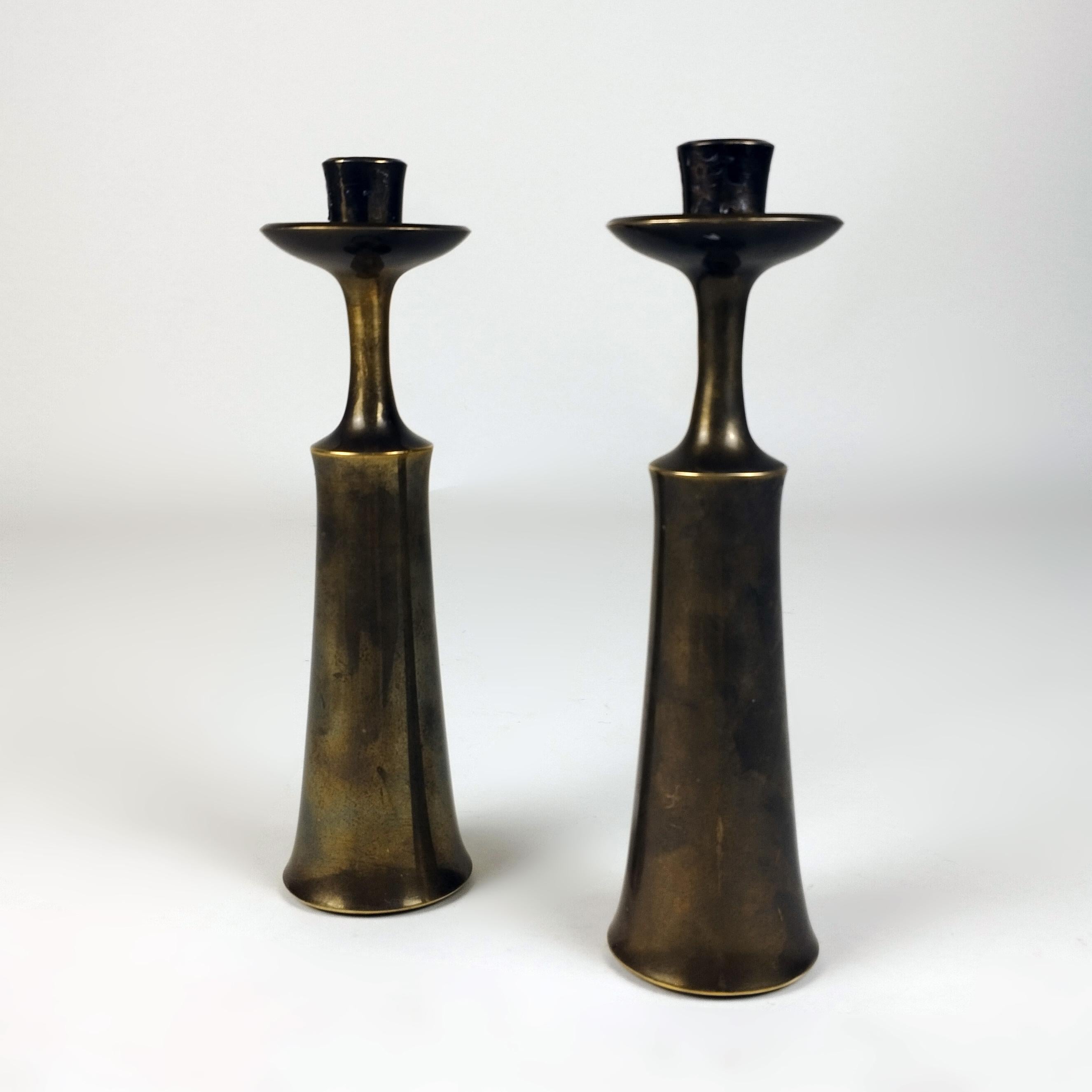 A pair of Danish 1960's brass candle sticks by Jens Harald Quistgaard for Dansk Designs. Both candlesticks are sealed on the lower interior.