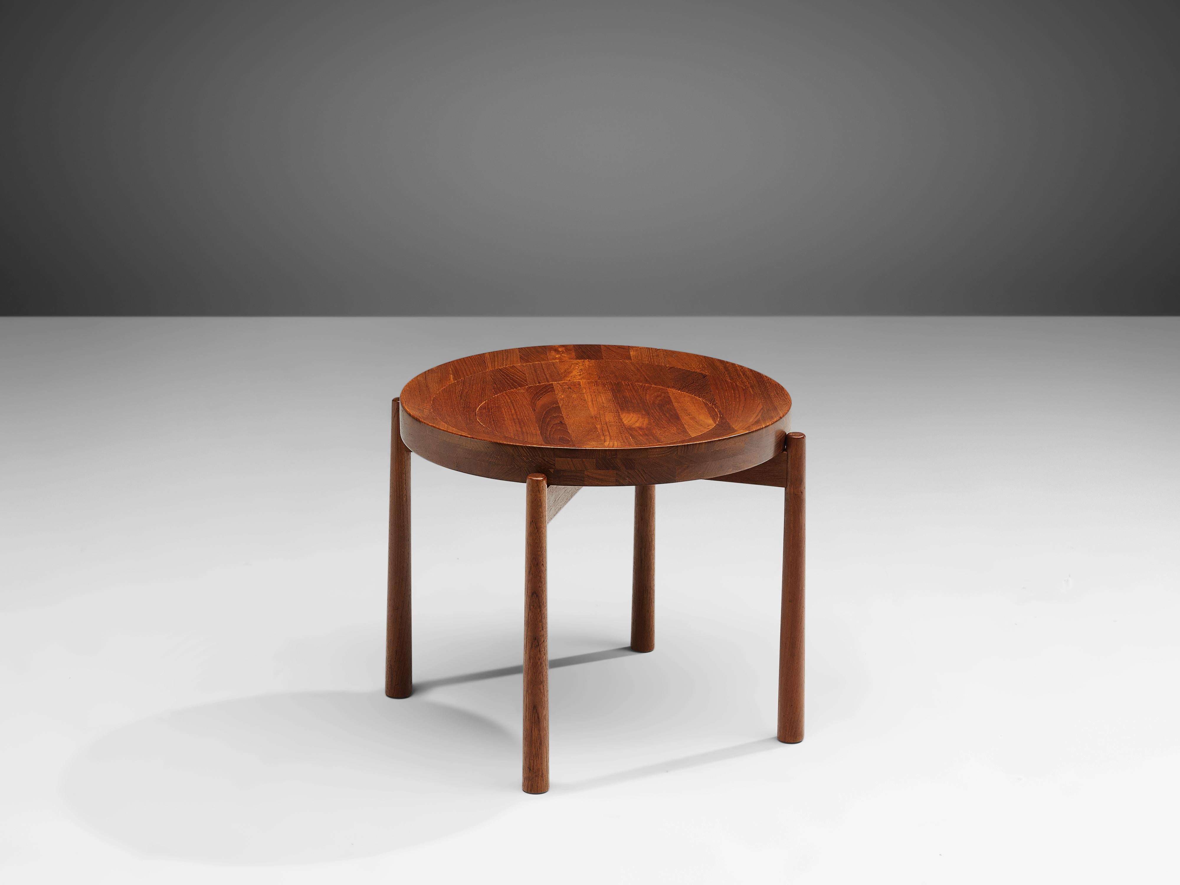 Side table in teak by Jens Harald Quistgaard for Nissen, Denmark, 1960s.

This exquisite side table features round a round teak top that is slightly denting towards the middle, making the table top resemble a bowl. The legs of the table is joint