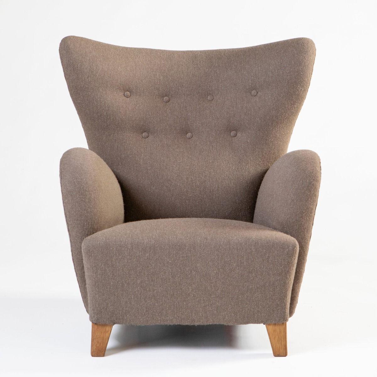 Chaise longue élégante aux formes organiques, conçue par Jens Houmøller Klemmensen vers 1940 et fabriquée par Skive Møbelfabrik.
Le profil sculptural de la chaise se caractérise par un dossier légèrement incurvé et des accoudoirs arrondis, créant